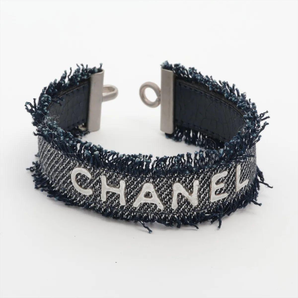 Il braccialetto Chanel Logo Denim è un accessorio audace ed elegante che fonde il fascino casual con il lusso iconico. Fabrice in resistente tessuto denim avvolto intorno a un braccialetto strutturato, mostra il logo del marchio in un design