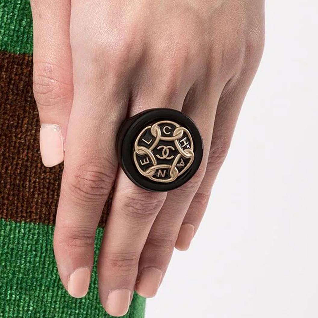 Bold and chunky, this pre-owned Chanel ring has been crafted from resin and features a gold chain detail with a different letter of Chanel in each link, finished with the iconic CC logo in the centre. Wear it solo on your index or middle finger for