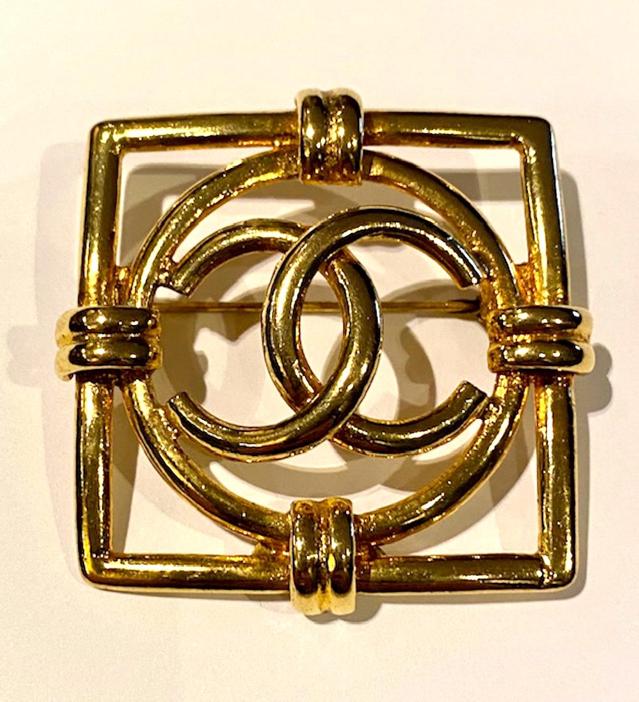 A very very nice Chanel square pin with central Channel CC logo in a circle. The round logo is lightly domed. The pin is a rich gold tone with no wear. It measures just a hair under 2 inches square and 3/8 of an inch deep. The bottom back of the pin