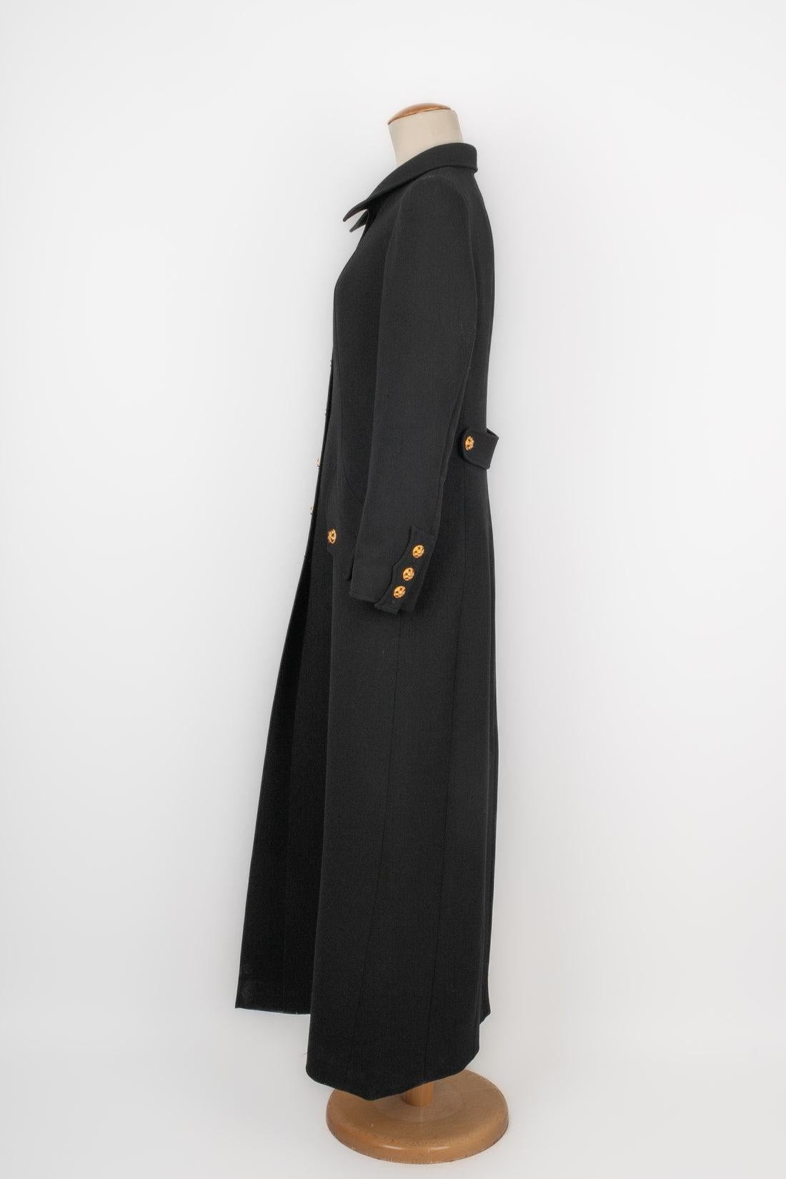 Chanel - (Made in France) Long black wool coat with golden metal jewelry buttons and glass paste cabochons. No size indicated, it fits a 36FR. A 1990s Collection.

Additional information:
Condition: Very good condition
Dimensions: Shoulder width: 39