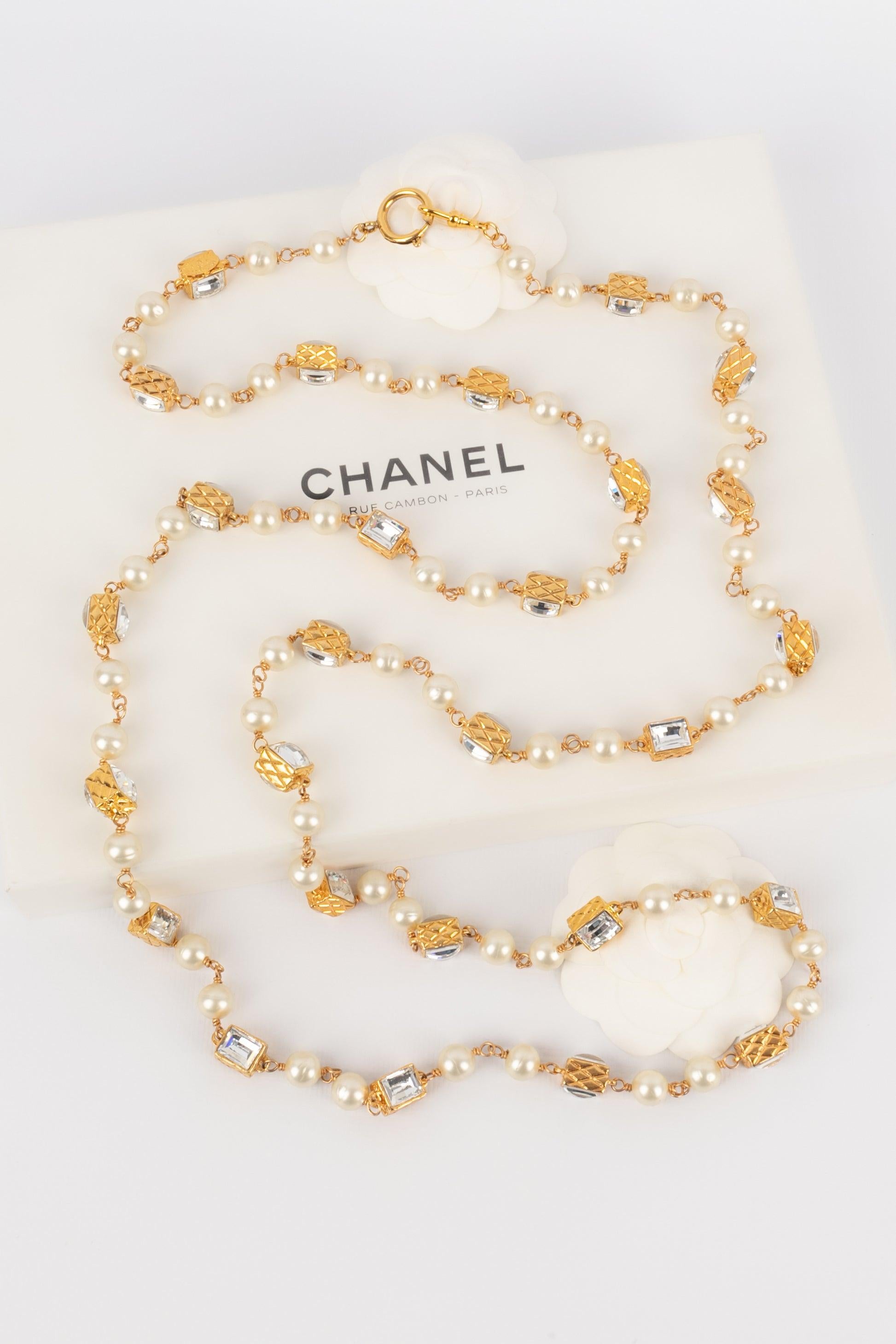 CHANEL - (Made in France) Long costume pearl necklace with golden metal quilted elements and Swarovski rhinestones.

Additional information: 
Condition: Very good condition 
Dimensions: Length: 160 cm

Seller Reference: CB231