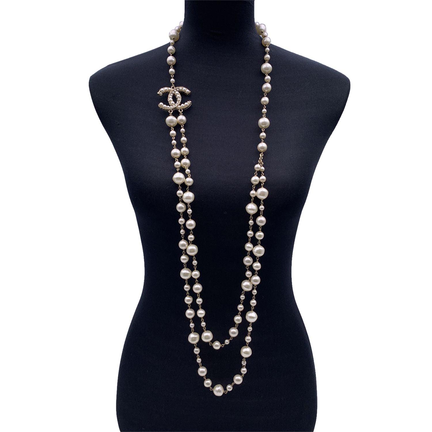 Long light gold metal double strand chain necklace by Chanel. It features artificial pearl beads in different sizes and CC logo embellished with small artficial pearls. Lobster closure. 'CHANEL - A11 CC A- Made in France oval tab on the closure.