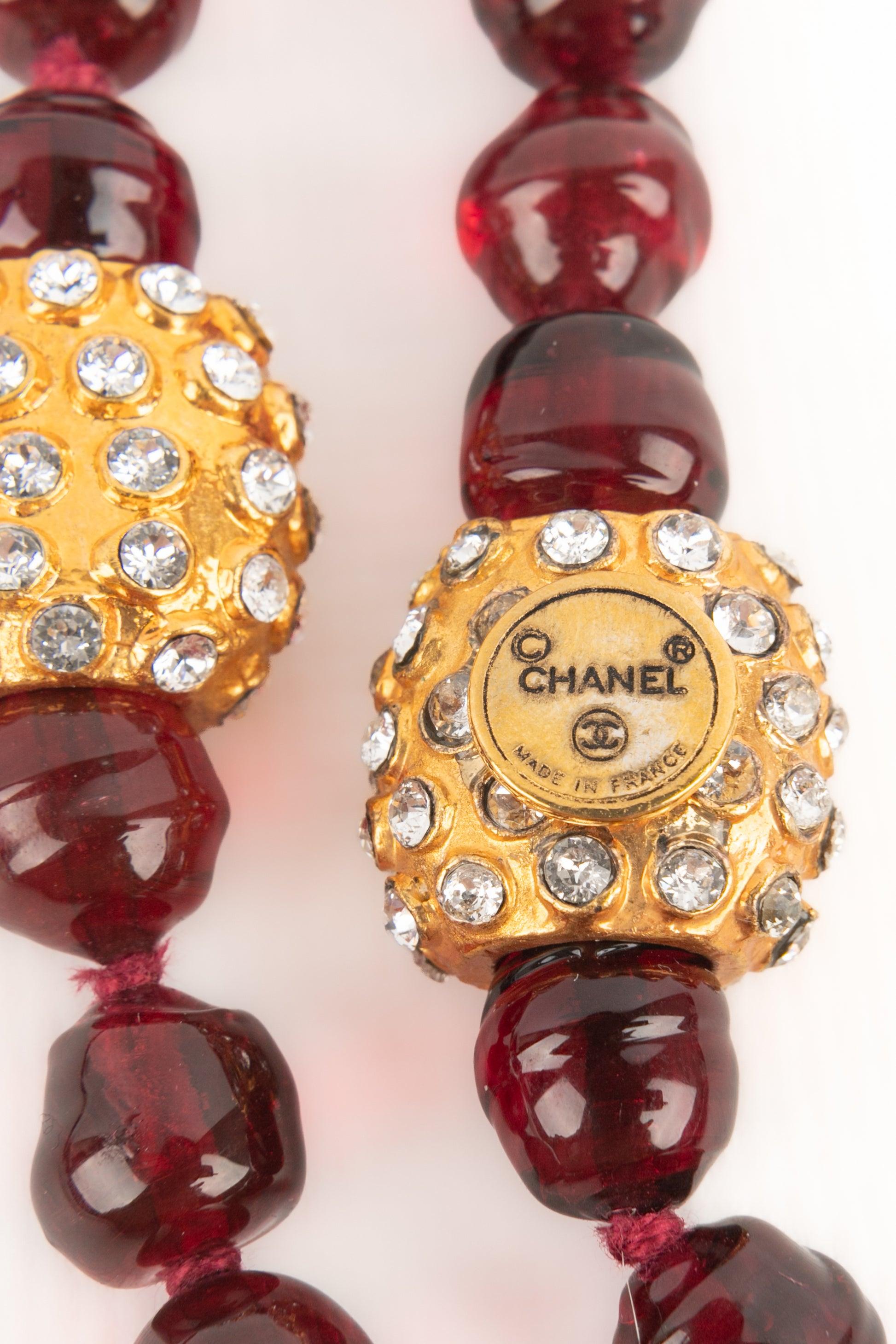 CHANEL - (Made in France) Long garnet-red glass pearl necklace with golden metal elements ornamented with rhinestones. Jewelry from the 1980s.

Additional information:
Condition: Very good condition
Dimensions: Length: 175 cm

SKU:CB147