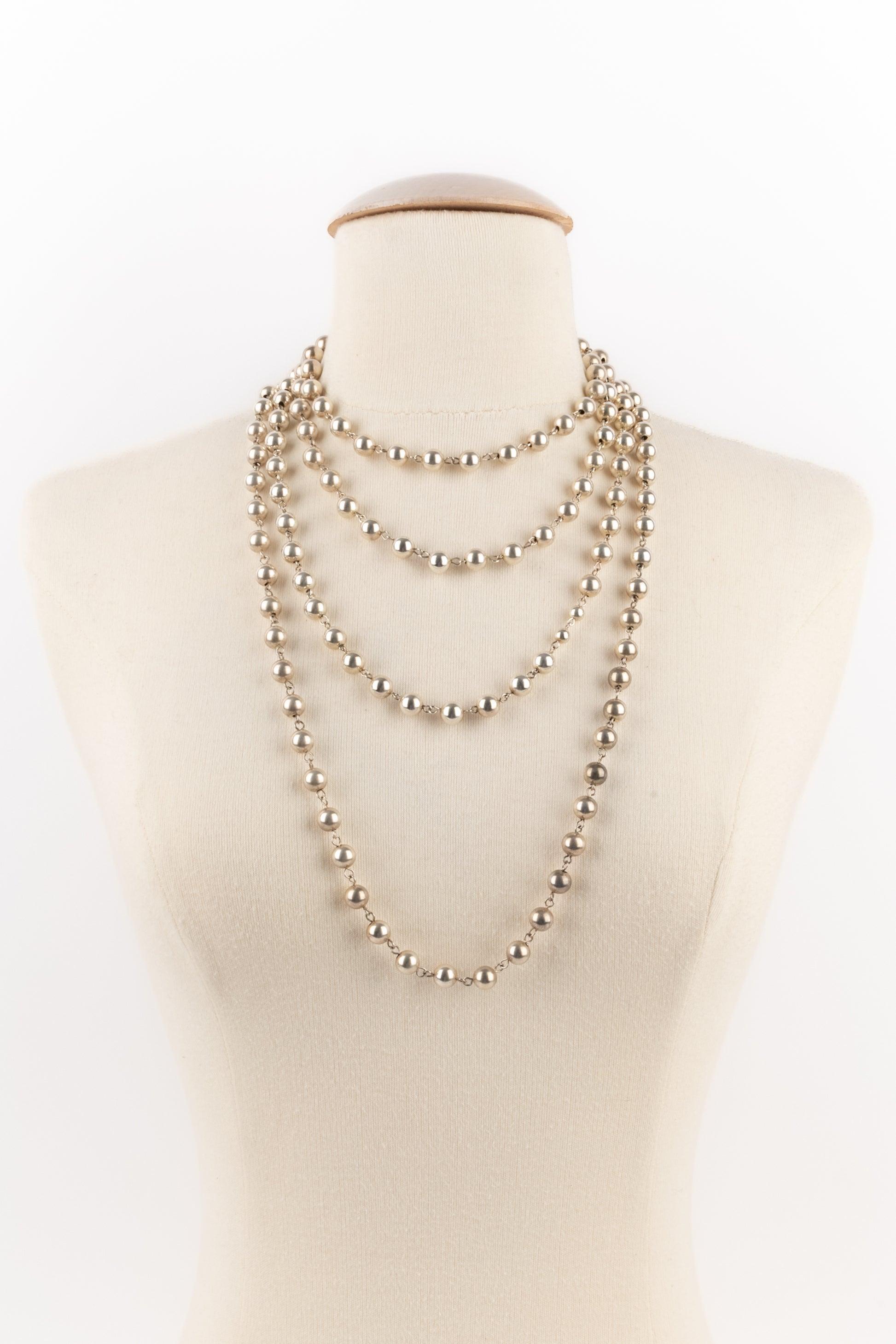 Chanel - (Made in France) Very long necklace made of silvery metallic pearls. There is a camellia near the fastener. Signature engraved on the stick.

Additional information:
Condition: Good condition
Dimensions: Length: 225 cm

Seller Reference: