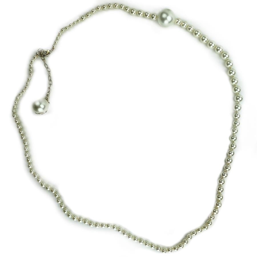 This sublime long necklace was created by the house CHANEL. It is composed of a row of pearls of three different sizes including two maxi-pearls which make the originality of the necklace. The last pearl is decorated with a double golden CC. The