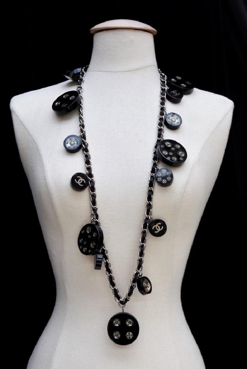 Chanel (Made in France) Long silver plated necklace adorned with black leather and bakelite charms. Fall-Winter 2003 collection.

Additional information: 

Dimensions: Length: 102 cm (40.16 in) 

Condition: Very good condition. Rare scratches upon