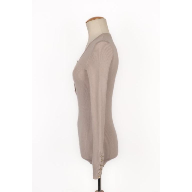 Chanel - Long-sleeved top sewn with resin and golden metal buttons. Size 40FR indicated. To be mentioned, the buttons are damaged.

Additional information:
Condition: Good condition
Dimensions: Shoulder width: 36 cm - Chest: 40 cm - Sleeve length: