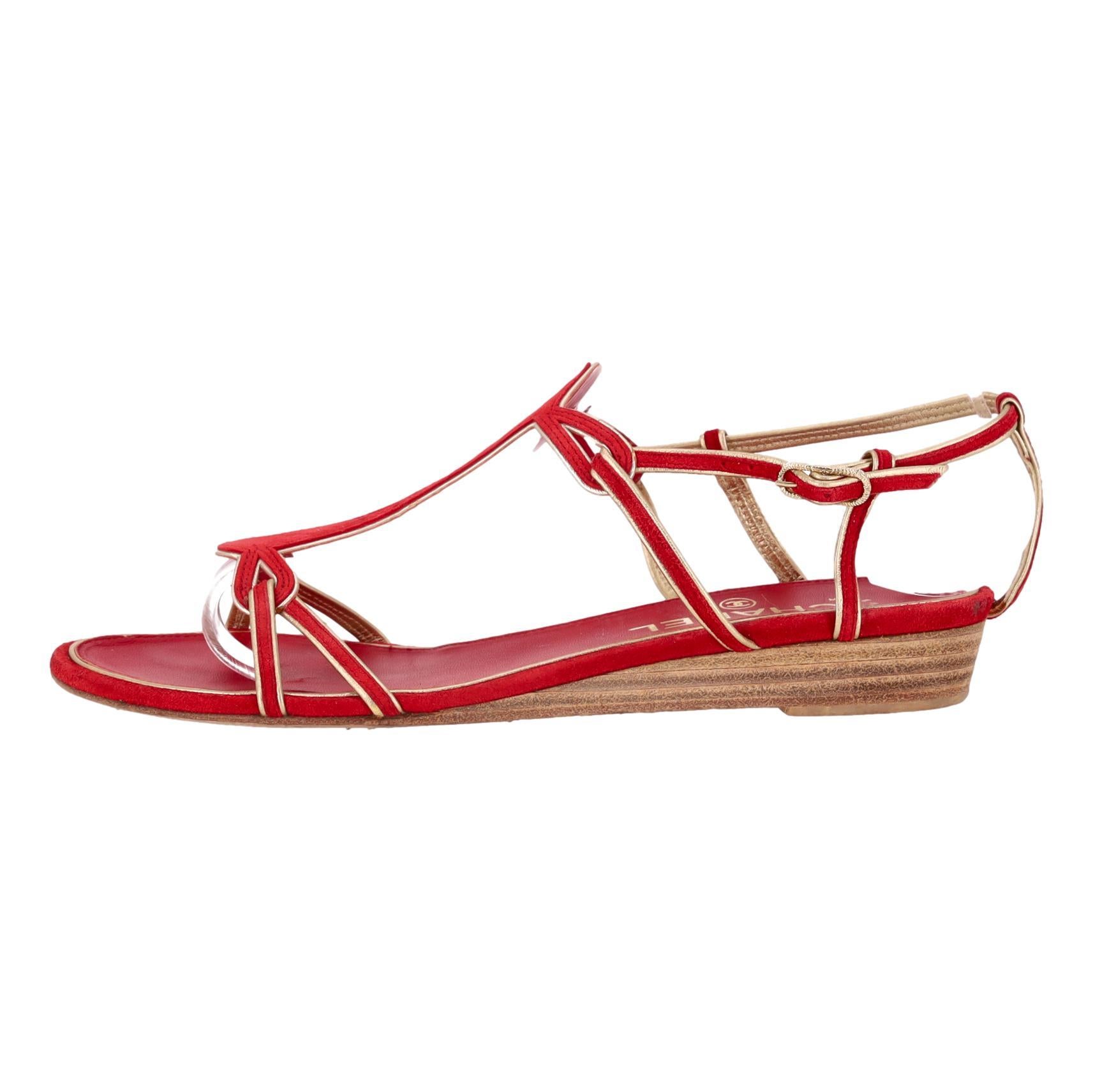 Chanel Low Wedge Suede Sandals With 'CC' Logo Detail

Red sandals crafted from suede adorned with gold leather trim.

Featuring a low wedge wooden heel embellished with iconic 'CC' logo accent.

Ankle strap with adjustable buckle closure, leather