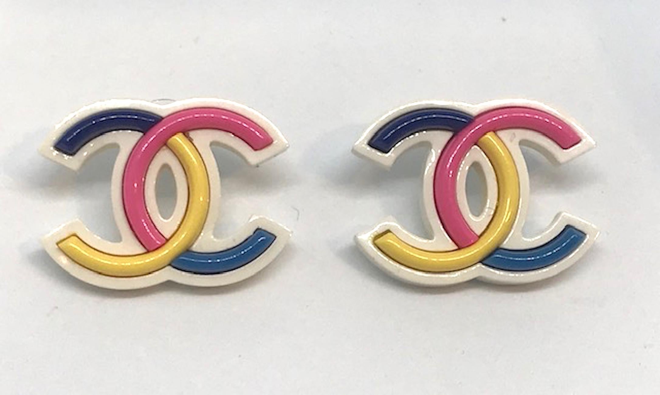 Fun and colorful with are these Chanel large logo earrings. Each lucite earring is meticulously set with black, pink, yellow and blue pieces into the white molded CC body. Each earring measures 1.5