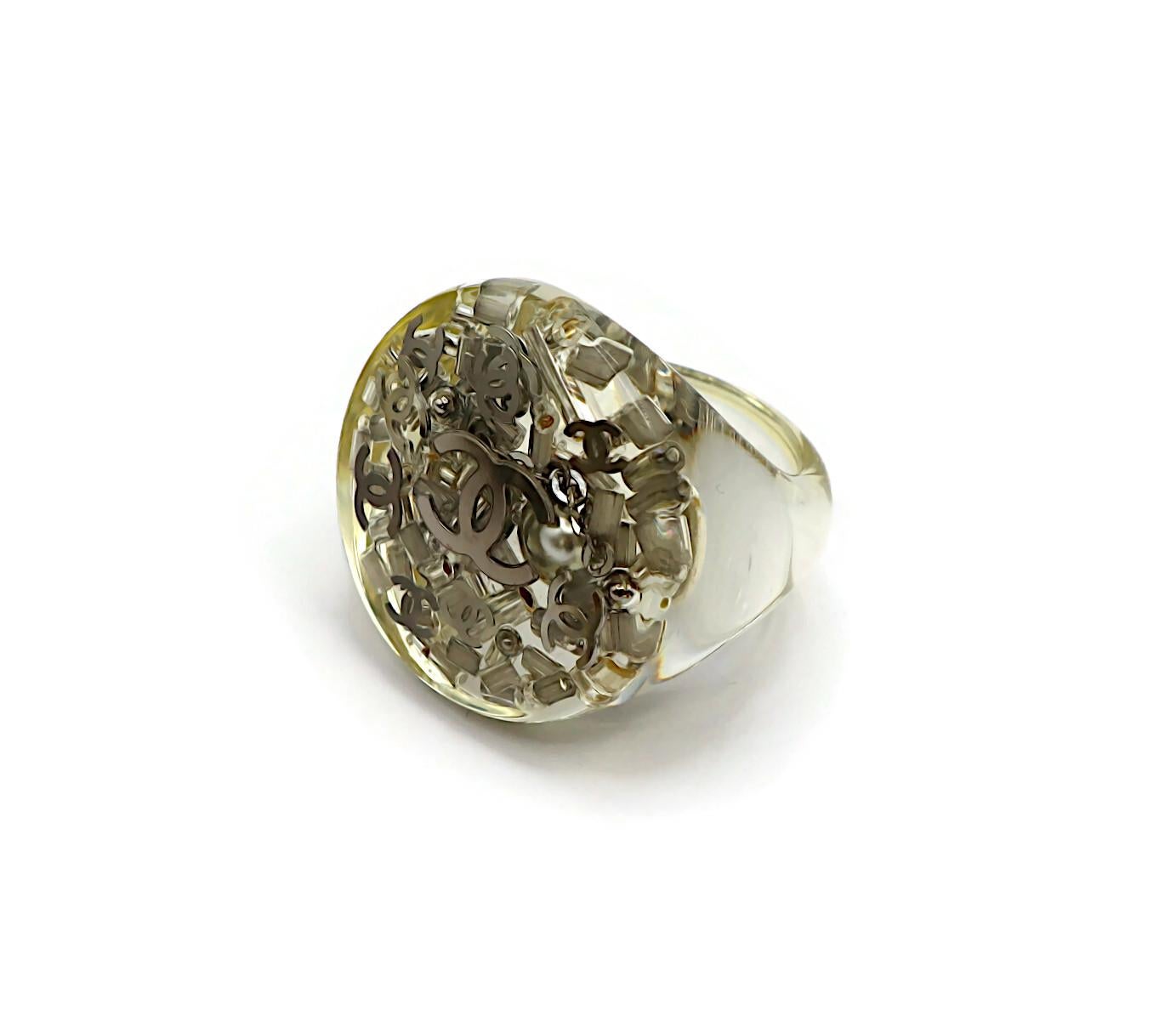 CHANEL lucite ring embellished with silver tone CC logos and beads.

Embossed CHANEL 13 B Made in France.

Indicative measurements : inner circumference approx. 5.34 cm (2.10 inches).

Material : Lucite / Silver tone metal hardware / Beads.

NOTES
-