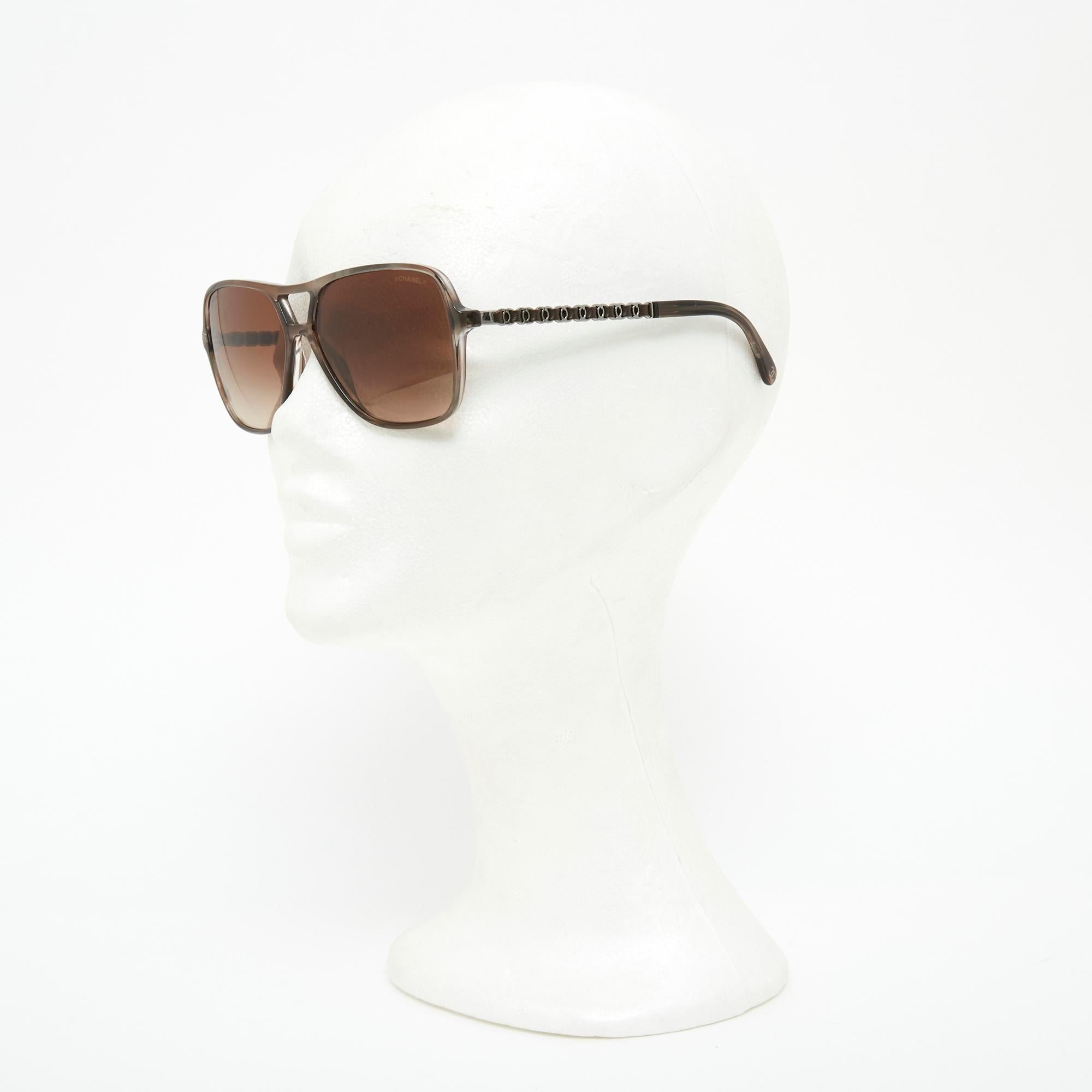 Chanel Pilot-shaped glasses in acetate and light brown leather, arms with CC logo pattern in silver metal interwoven with leather, lenses with gradient brown logo. Frame width 13.2 cm, dimensions of a lens 5.9 x 4.9 cm. The glasses are delivered
