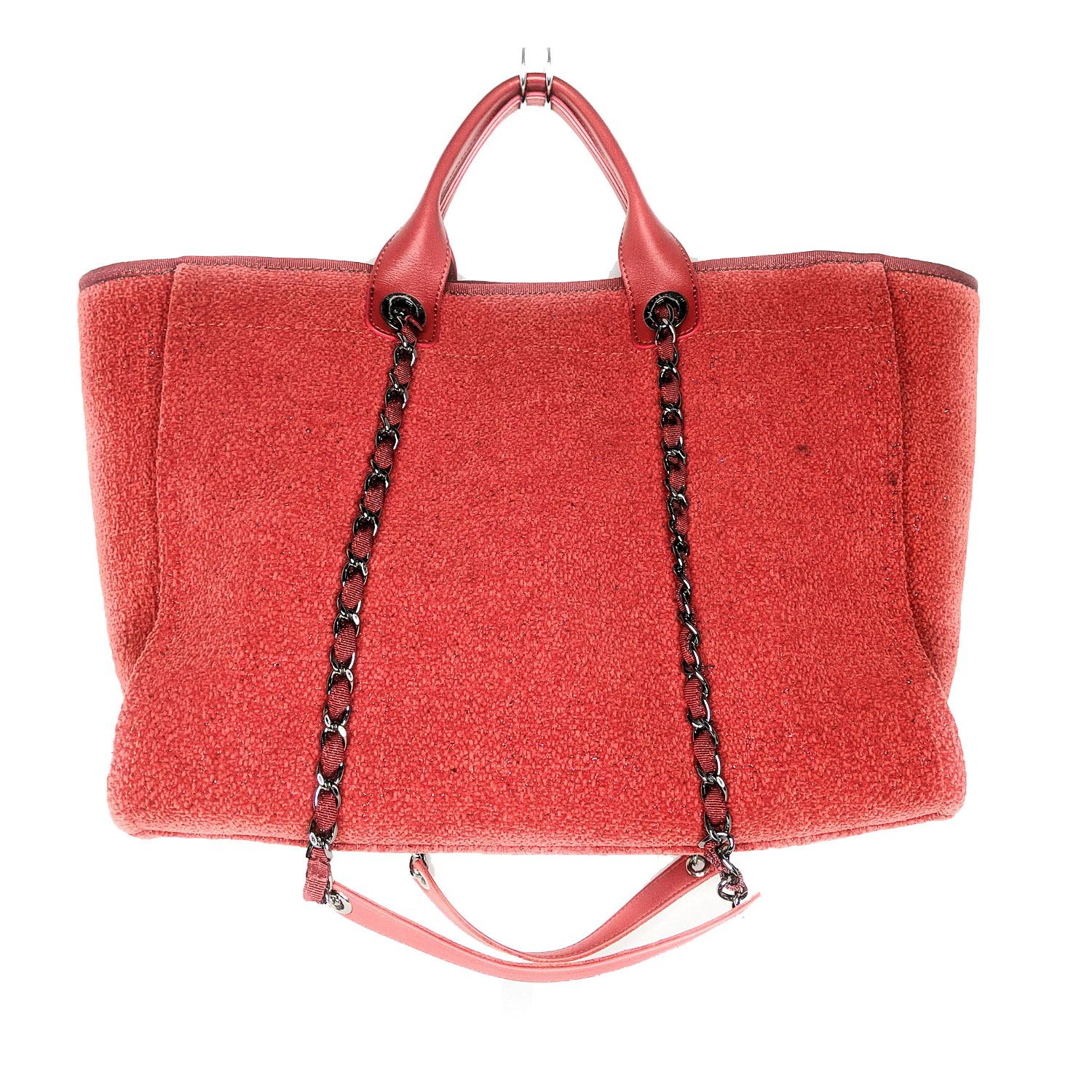 This lovely tote is crafted of fine red fabric with a dark silver Chanel advertisement logo. The shoulder bag features rolled red leather top handles and polished ruthenium chain-link fabric threaded shoulder straps. The broad top is open to a red