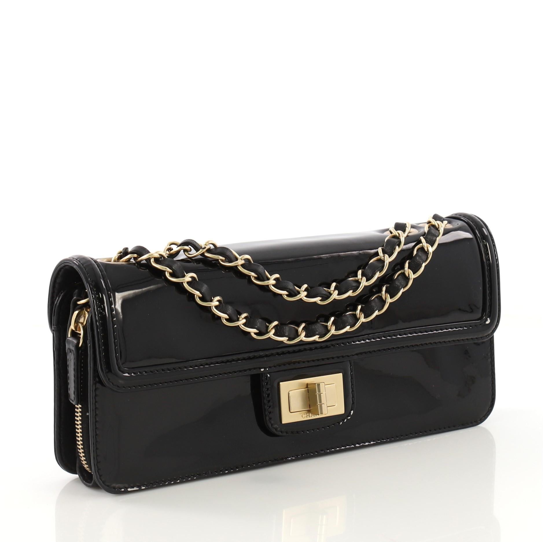 This Chanel Mademoiselle Flap Bag Patent East West, crafted from black patent leather east west, features woven-in leather chain strap and matte gold-tone hardware. Its mademoiselle turn-lock closure opens to a light pink fabric interior with middle