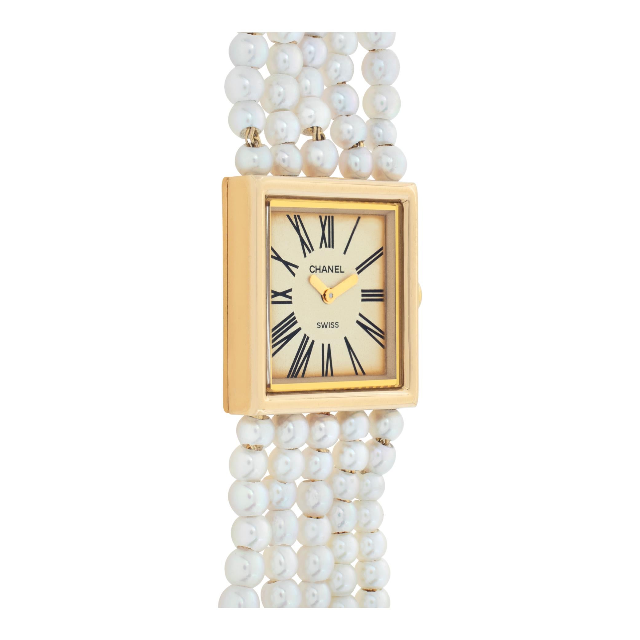 Chanel Mademoiselle in 18k yellow gold with 5 strands of pearls and 18k bracelet. Quartz. 22.4 mm case size. Will fit up to a 6.25