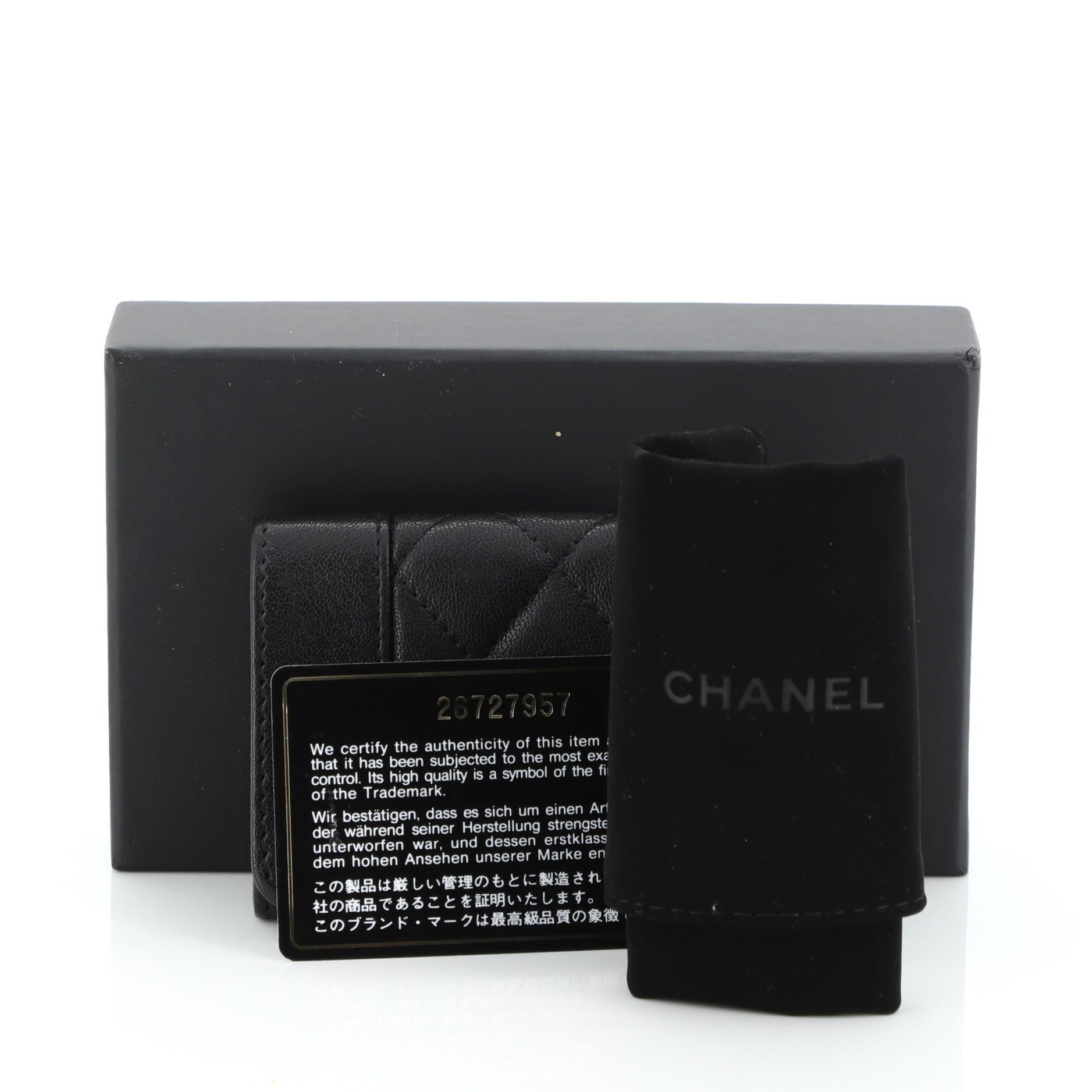 This Chanel Mademoiselle Vintage Flap Card Holder Quilted Sheepskin, crafted in black leather, features enamel Chanel CC log and gold and black-tone hardware. Its snap closure opens to a black fabric interior. Hologram sticker reads: 26727957.
