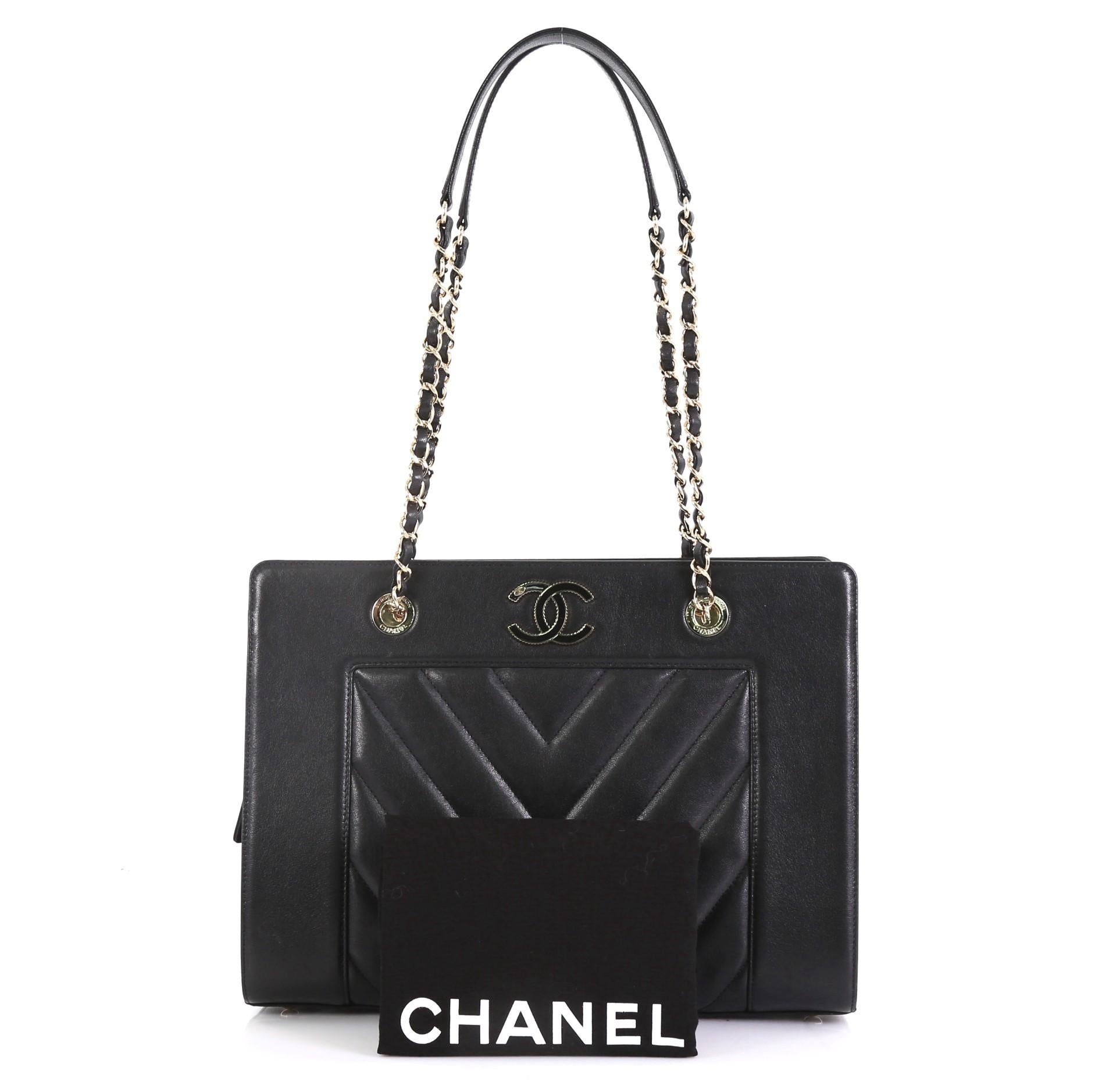 This Chanel Mademoiselle Vintage Shopping Tote Chevron Sheepskin Medium, crafted in black chevron sheepskin leather, features woven-in leather chain straps with leather pads, textured Chanel CC logo, protective base studs and gold-tone hardware