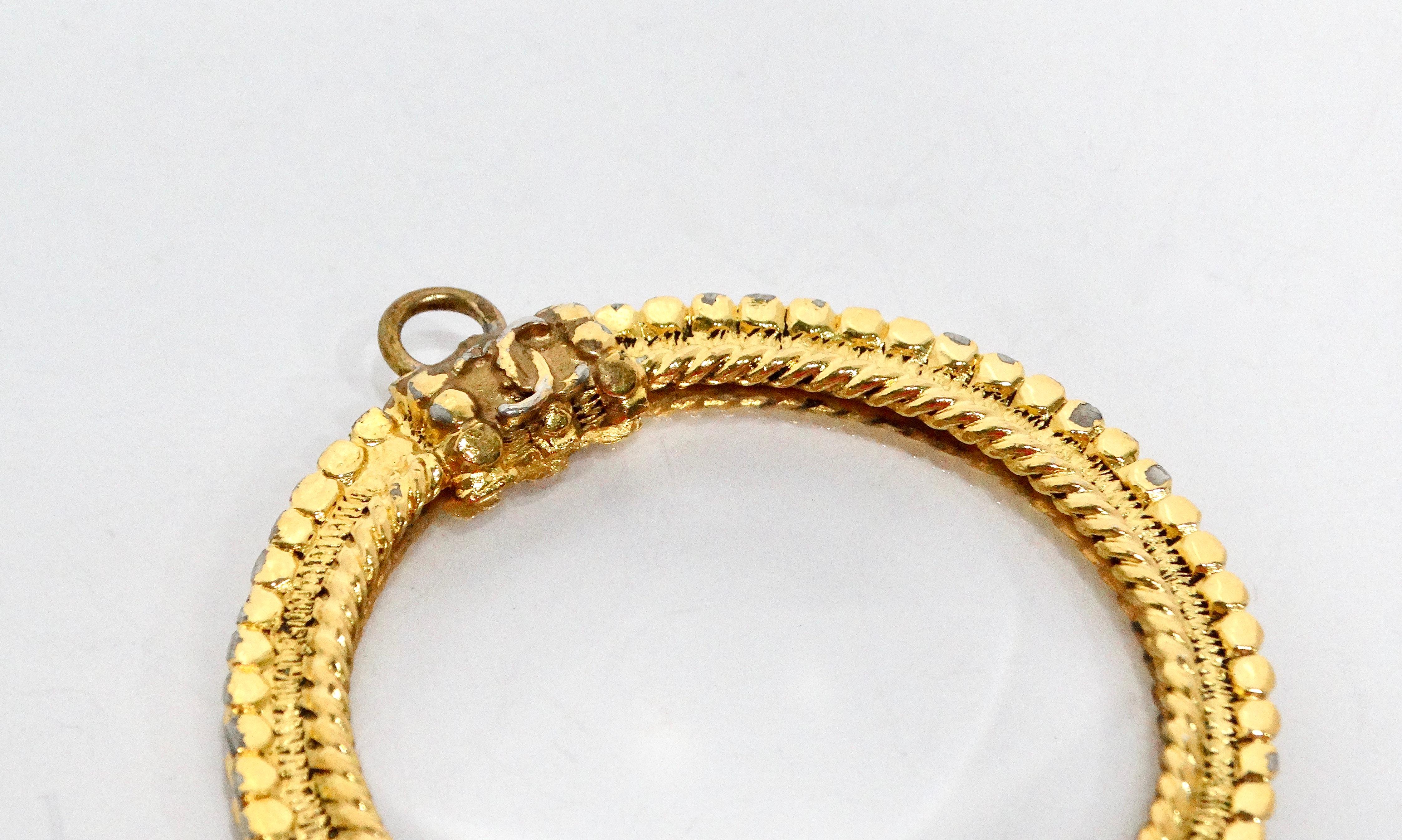 Ce pendentif vintage en plaqué or en forme de loupe de Chanel est une incarnation étonnante de l'élégance et du style. Fabriqué en plaqué or jaune, le pendentif présente un design rond distinctif avec un logo CC classique gracieusement positionné au
