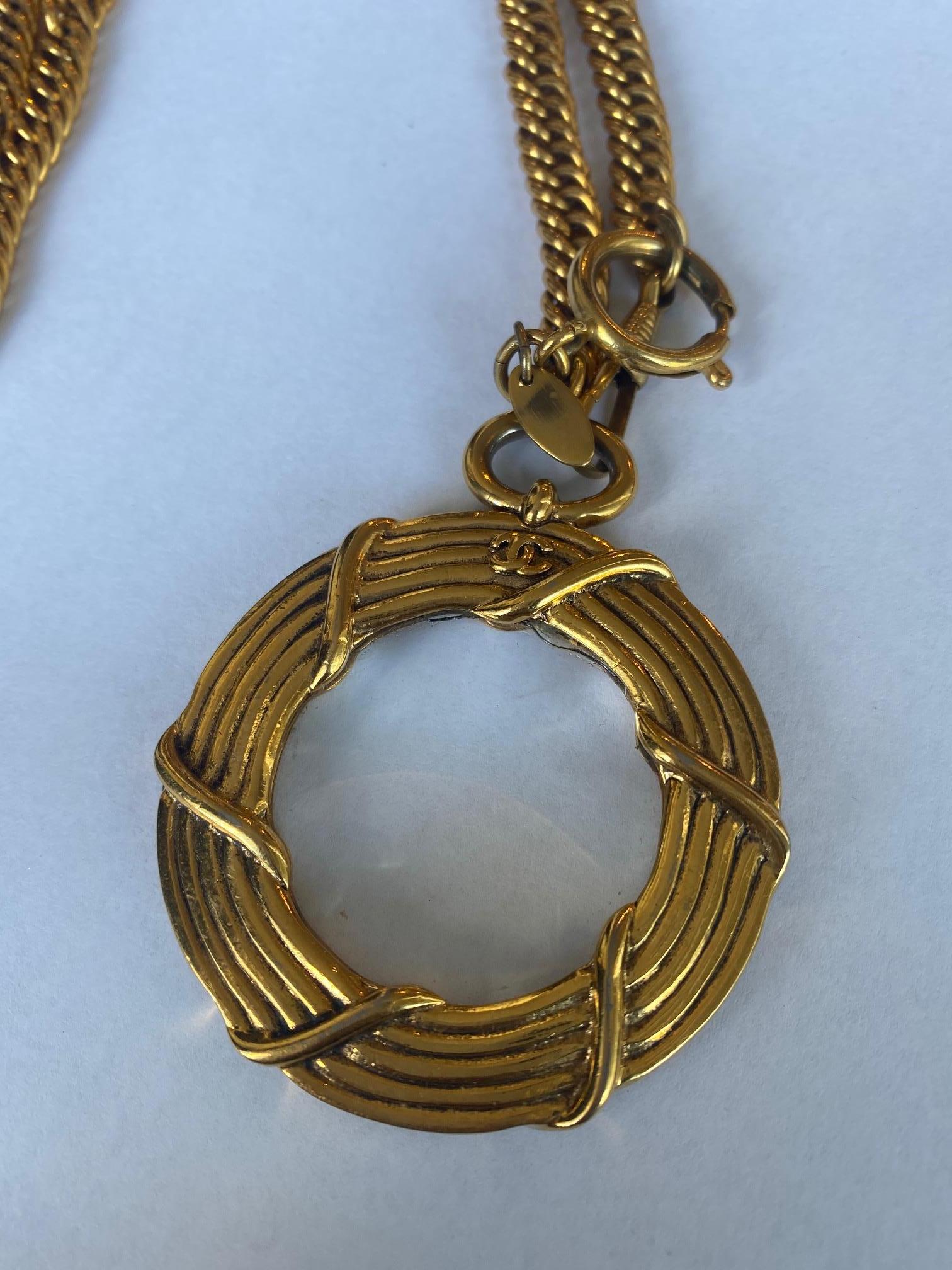 Rare vintage Chanel piece. Double chain necklace. Magnifying glass pendant. Twisted metal design around the glass features a small CC logo on top of each side.
