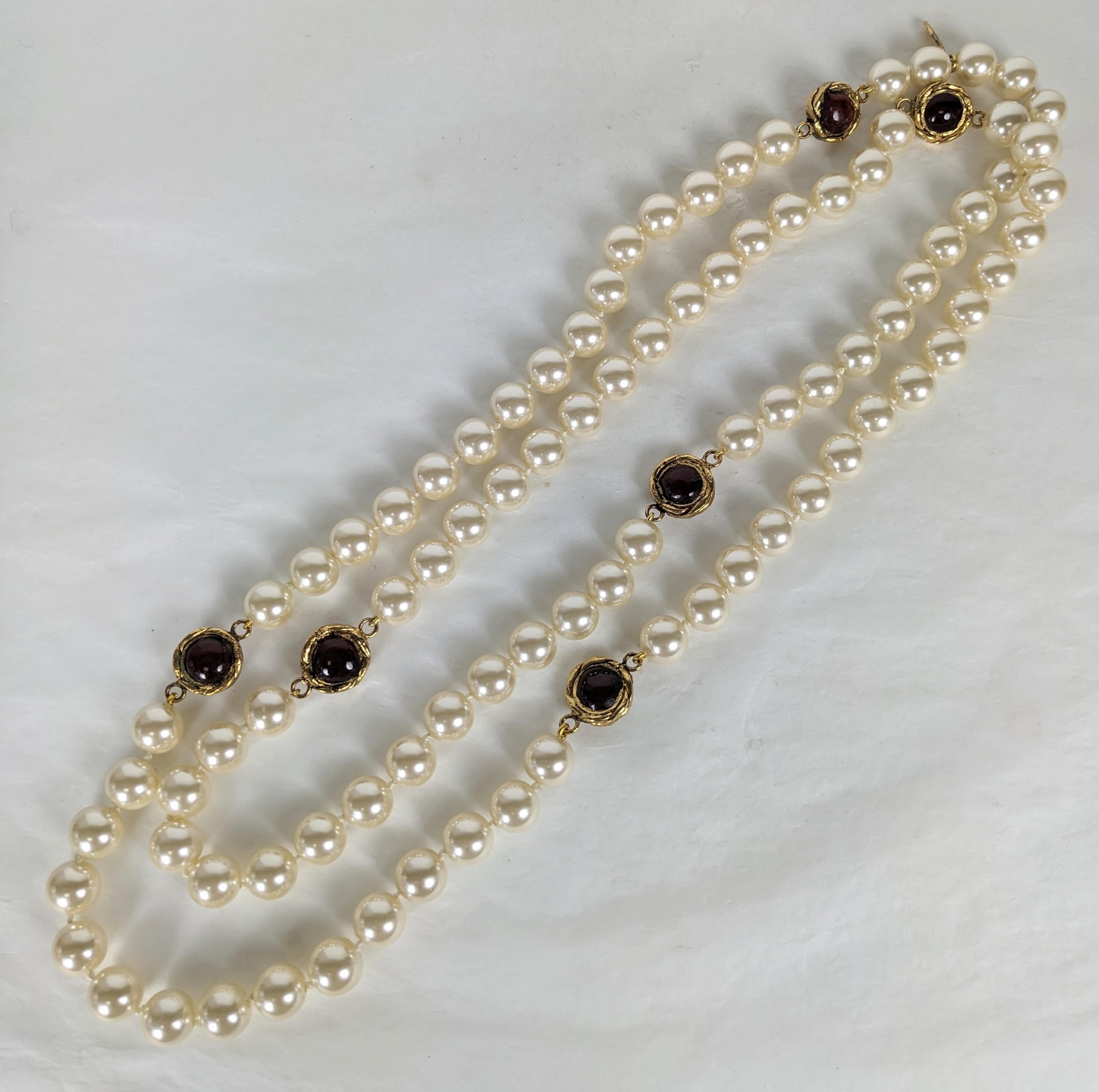 Iconic Chanel Byzantine link endless faux pearl necklace. Composed of continuous Maison Gripoix hand knotted glass faux pearls with hand made Maison Gripoix poured glass round ruby enamel in gilt bronze reversible cabochon stations. Excellent