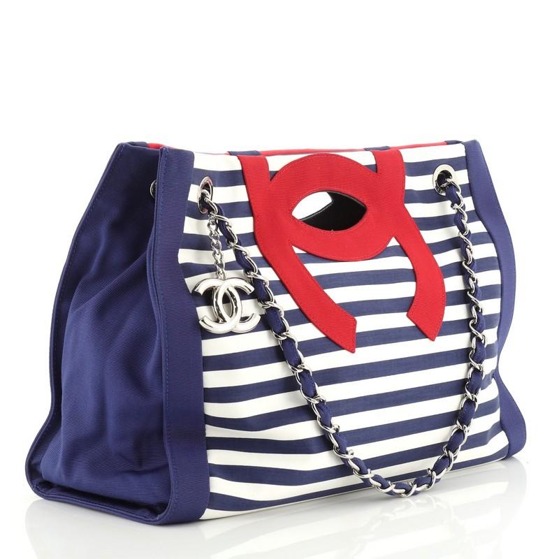 This Chanel Mariniere Chain Tote Striped Canvas Small, crafted in white, blue and red striped canvas, features dual woven-in canvas chain straps, cutout top handles, and silver-tone hardware. Its wide open top showcases a blue denim interior with