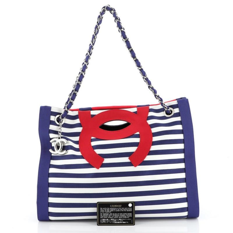 This Chanel Mariniere Chain Tote Striped Canvas Small, crafted in blue striped canvas, features dual woven-in canvas chain straps, cutout top handles, and silver-tone hardware. Its wide open top showcases a blue denim interior with zip and slip