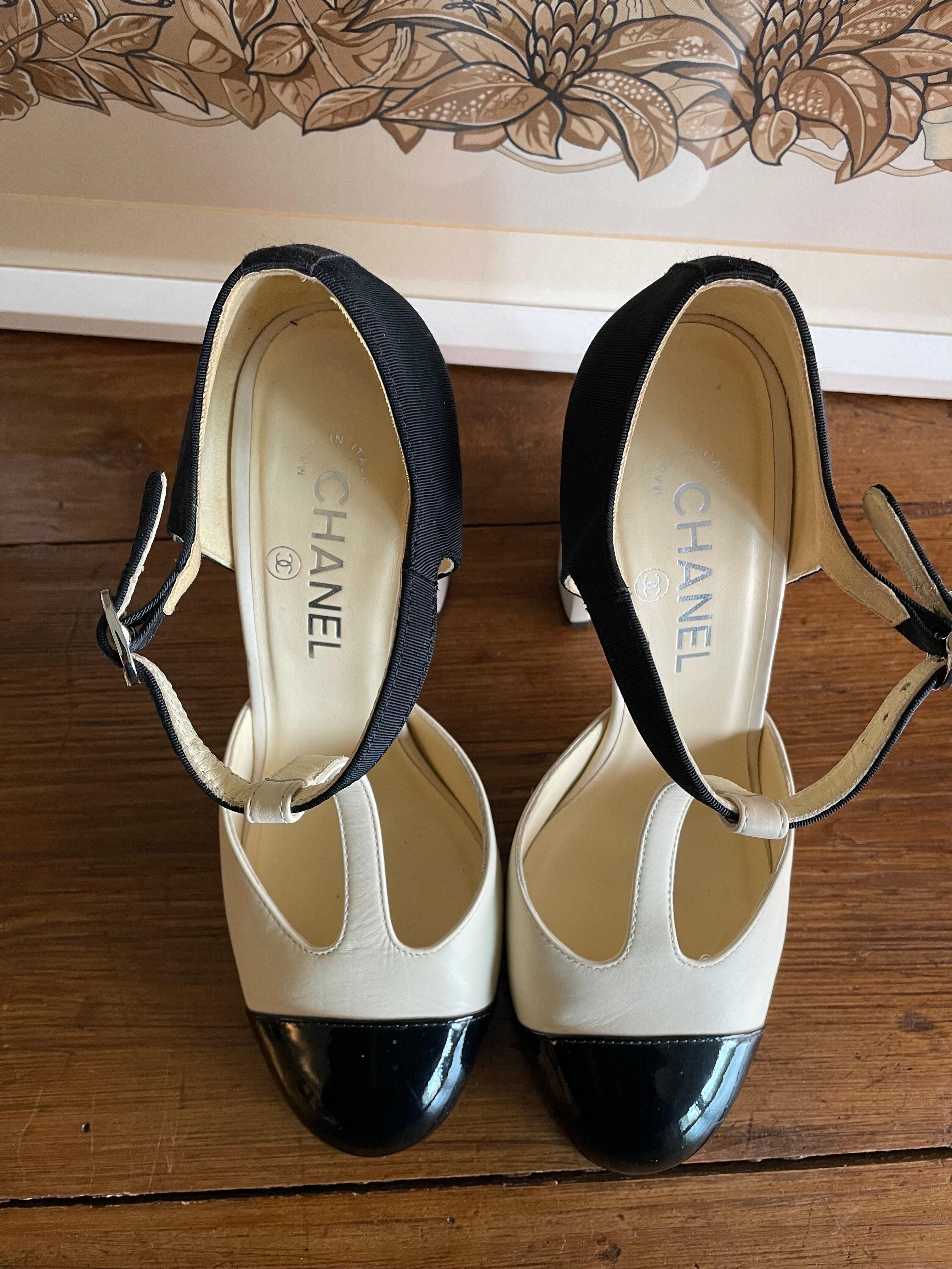 Mary Jane Chanel in light beige leather with black patent leather toe and black satin detail on the back. Adjustable ankle strap. Leather chain detail on the heel. Number 39. 
Heel 10 cm. With original dust. 
It has some signs of use but is well