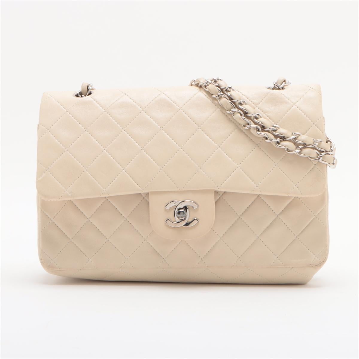 The Chanel Matelassé 25 Lambskin Double Flap Double Chain Bag in White is a timeless piece of luxury, epitomizing Chanel's iconic design and craftsmanship. Made from soft, quilted lambskin leather, the bag features a classic matelassé pattern that