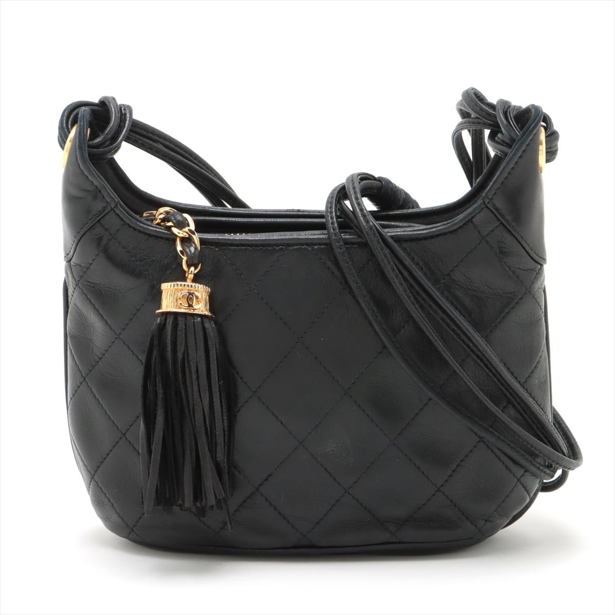 The Chanel Matelassé Lambskin Tassel Shoulder Bag in Black epitomizes sophistication and chic style. Crafted from luxurious lambskin leather, the bag features Chanel's iconic quilted design, a timeless symbol of elegance. The addition of a playful