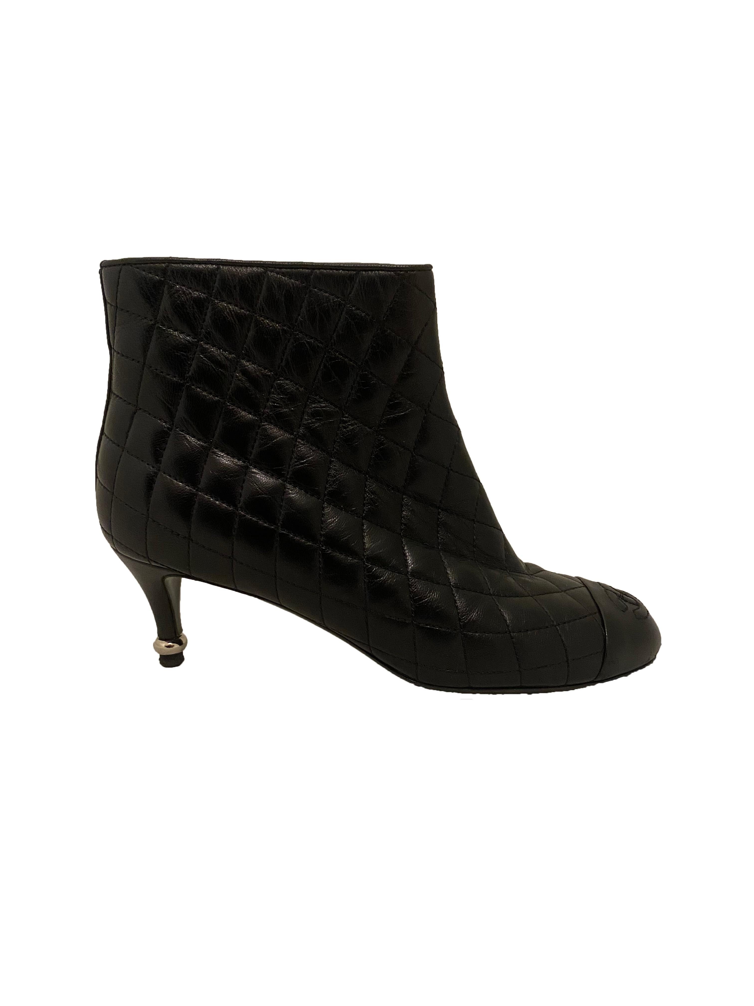 Black quilted, matelasse leather ankle boots from Chanel. Rounded toe with interlocking 'CC' Chanel logo stitching and 6cm leather kitten heel embellished with silver toned metal bead detail. Zipped up the inner ankle with leather zip pull. Marked