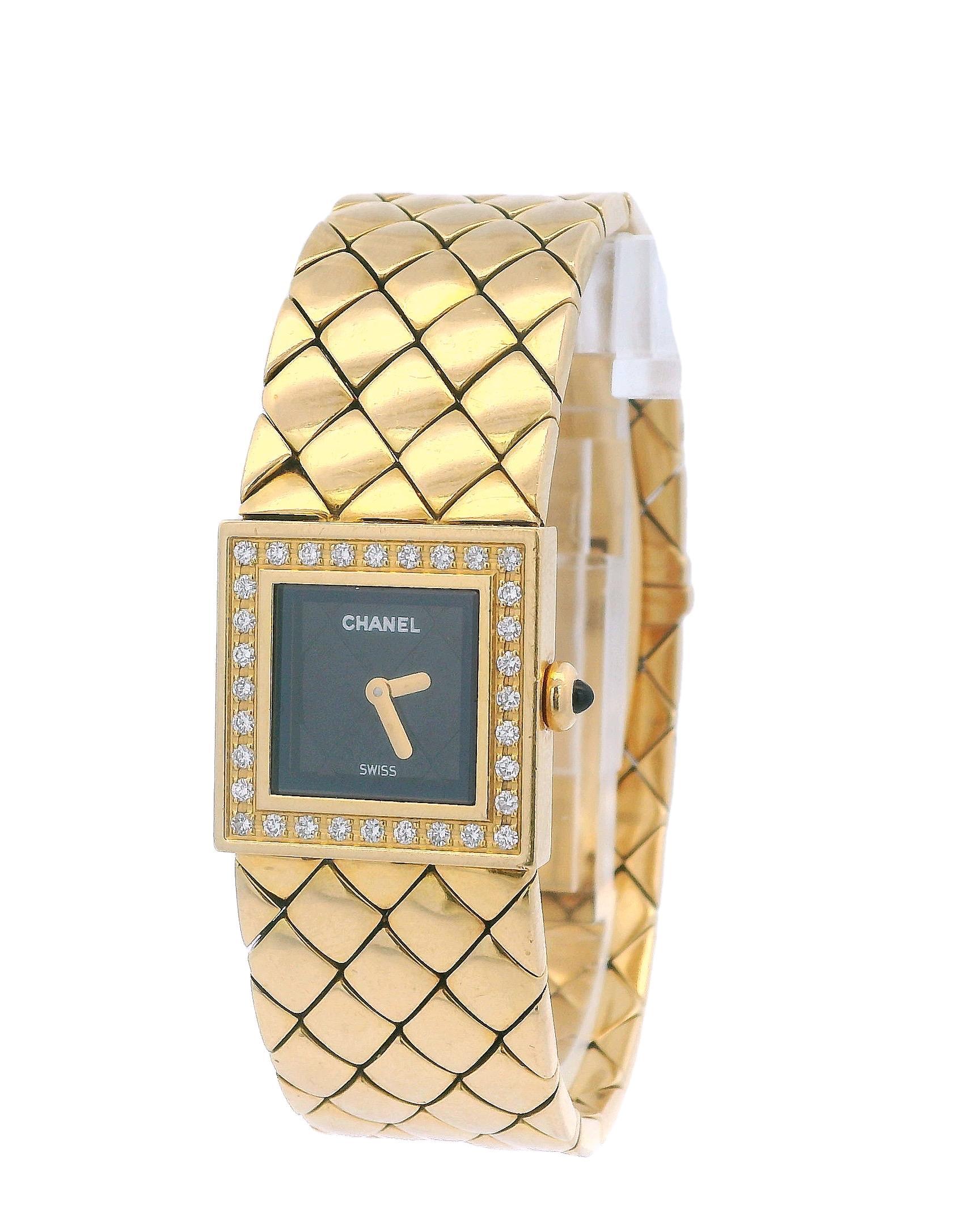 Chanel Matellasse Ladies' Watch. Features a 29mm 18K yellow gold case and an 18K yellow gold bezel adorned with the original factory diamond insert. The watch has a black dial with gold hands and an 18K yellow gold bracelet that includes a hidden