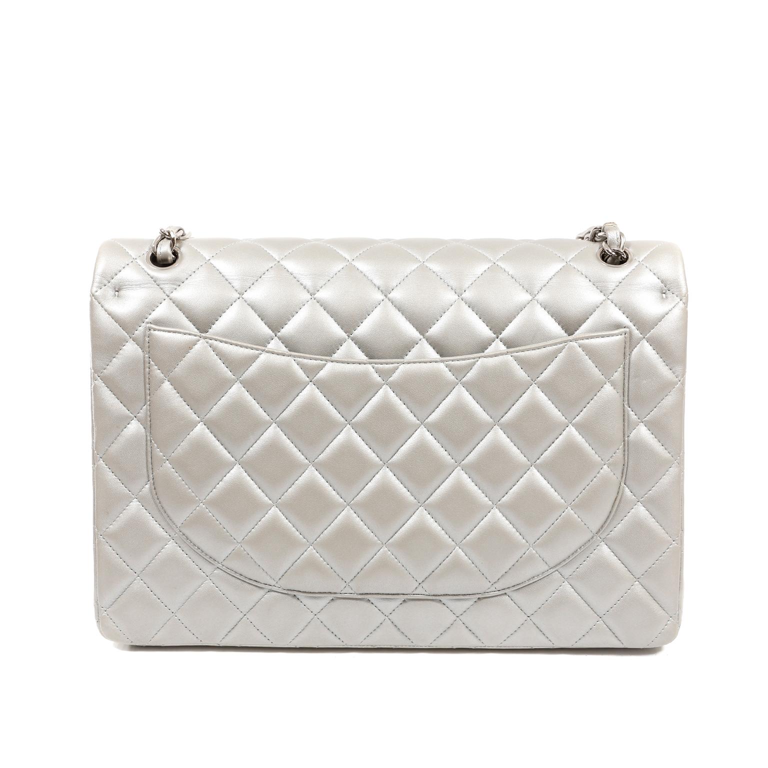 Diese authentische Chanel Matte Silver Lambskin Maxi Classic Flap ist in sehr gutem Zustand.  Das matte Silberfinish macht diesen zeitlosen Klassiker besonders glamourös.  
Gedämpftes silberfarbenes Lammleder ist mit dem für Chanel typischen