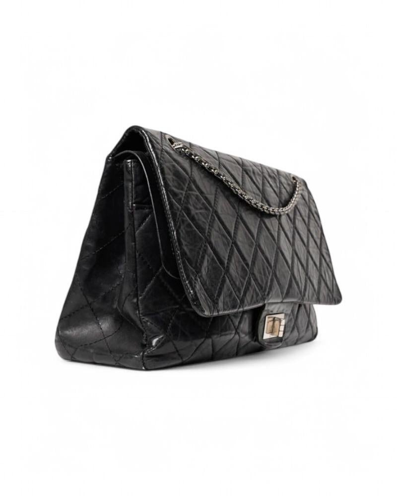 Chanel signature bag, model Reissue in Maxi Jumbo size, made of smooth leather in black coloring with silver hardware. This model has a double button closure and an external swivel closure, internally lined in burgundy leather with convenient