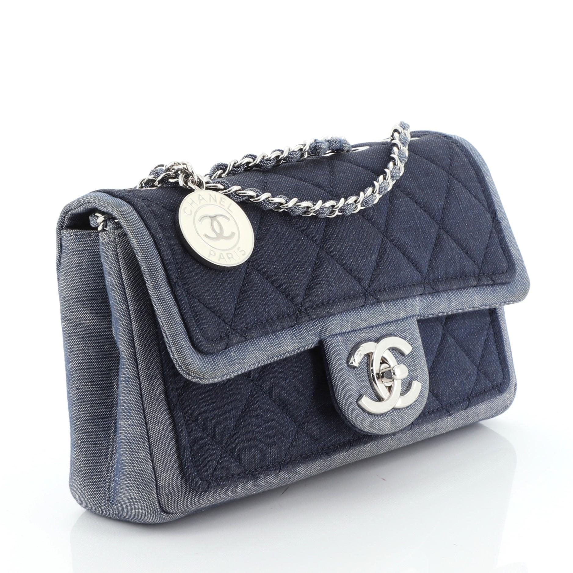 This Chanel Medallion Graphic Flap Bag Quilted Denim Small, crafted in blue quilted denim, features woven-in denim chain strap and silver-tone hardware. Its CC turn-lock closure opens to a blue fabric interior. Hologram sticker reads: 20631807.