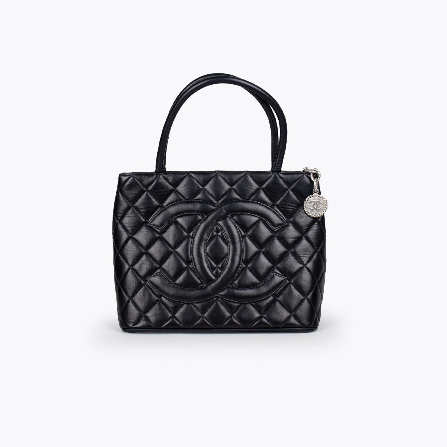 Black quilted lamb leather Chanel Medallion tote with

- Silver-tone hardware
- Dual rolled shoulder straps
- Patch pocket at exterior back
- Tonal leather interior, dual pockets at interior wall; one with zip closure and zip-closure at top