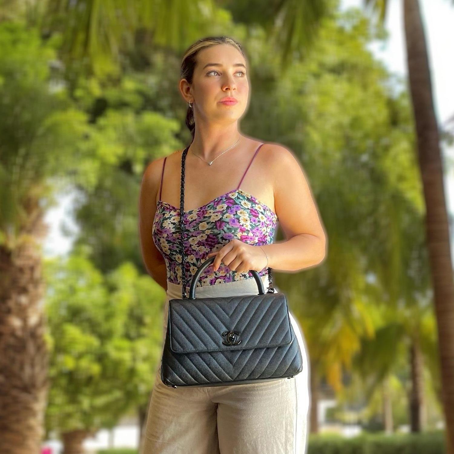 This chic tote is crafted of diamond stitched grained caviar calfskin leather in gunmetal. The shoulder bag features a sturdy leather top handle, a black chain link leather threaded shoulder strap with a shoulder pad, a rear patch pocket, and a