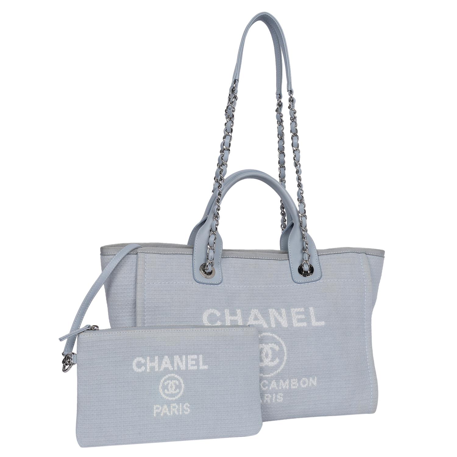 Authentic, pre-loved Chanel Deauville shoulder bag tote. Features baby blue canvas, silver-tone hardware, leather handles with dual shoulder straps with chain-link and blue trim, white embroidered logo embellishment at front face, tonal canvas