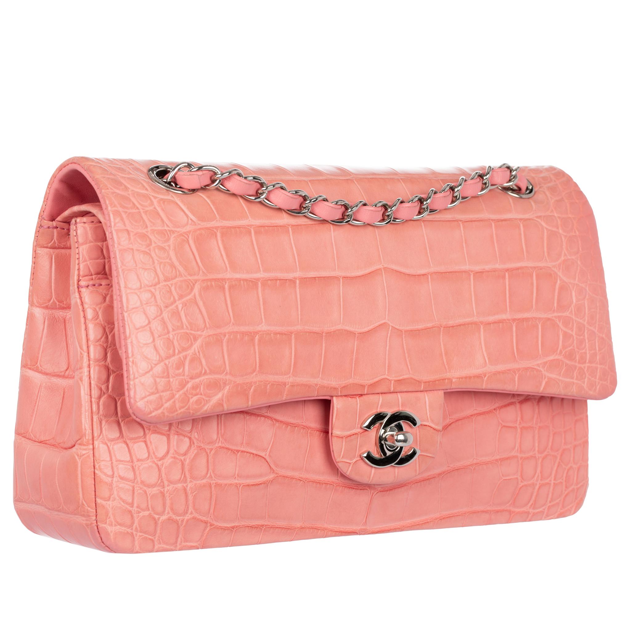 This Chanel Medium Double Classic Flap Bag is truly a rare gem. This model is no longer produced, making it a must-have item for any bag collector. Constructed from coral pink matte crocodile leather and silver tone hardware, it is the perfect