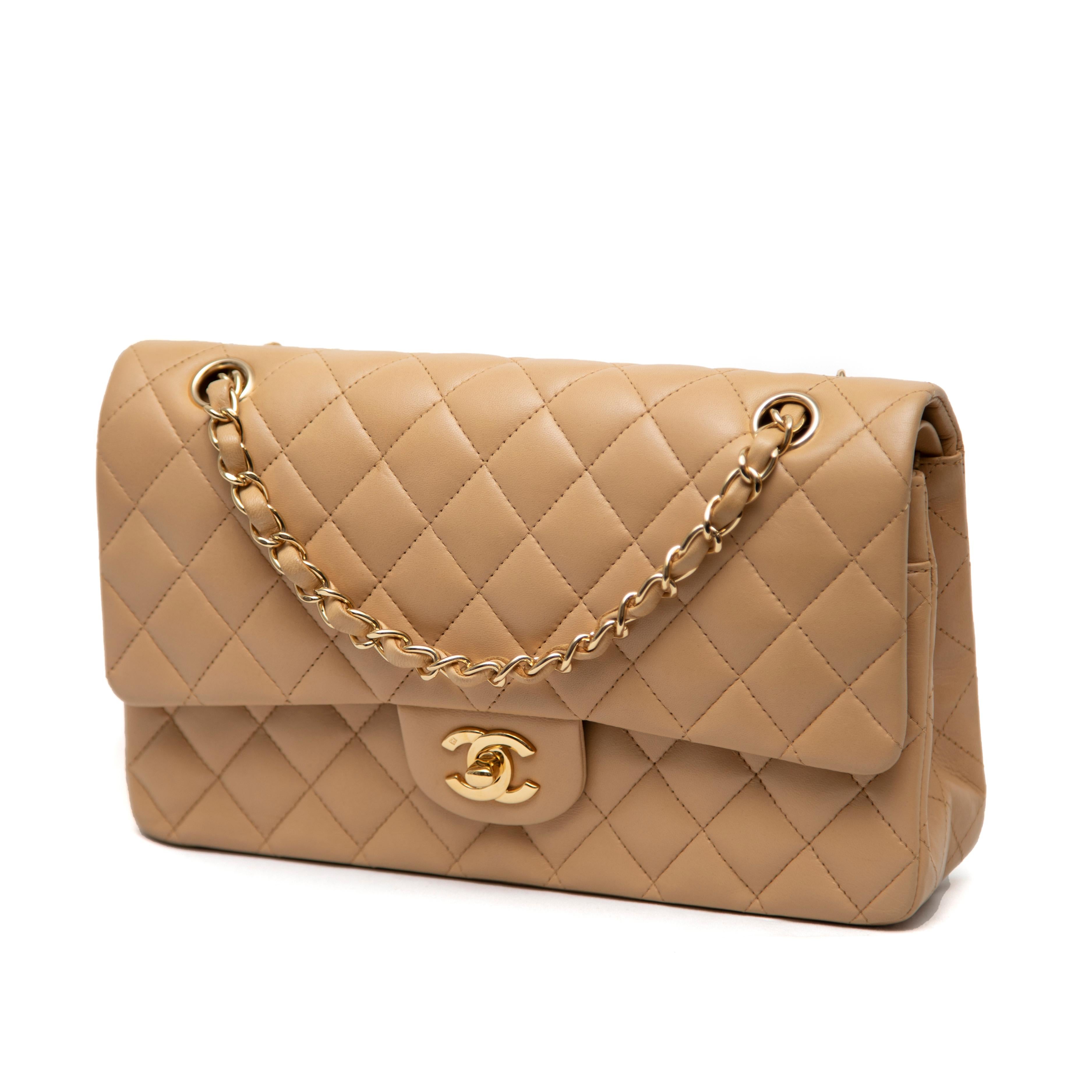 El bolso Chanel mediano con doble solapa de piel de becerro acolchada color topo y herrajes dorados es una pieza sofisticada y atemporal de la colección 2006-2008. Este elegante bolso presenta el estampado de rombos característico de Chanel en suave