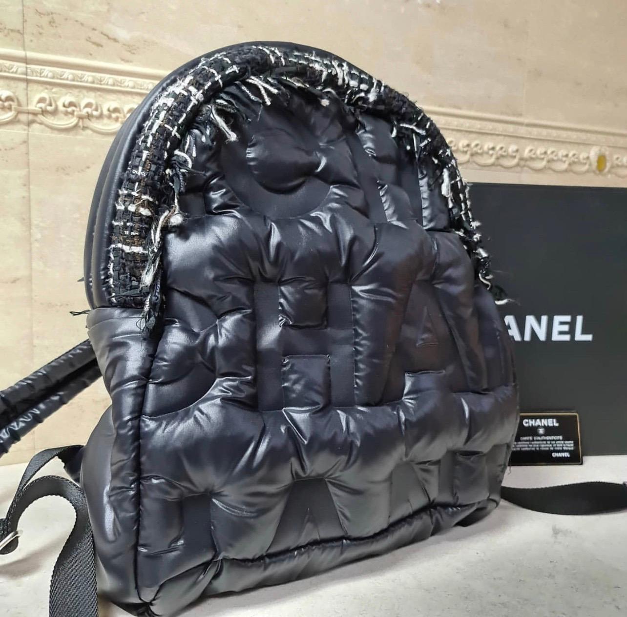 Chanel Doudoune Backpack Embossed Nylon with Tweed Medium
This Chanel Doudoune Backpack Embossed Nylon with Tweed Medium, crafted from black embossed nylon with tweed, features a top handle, adjustable shoulder straps, large embossed CHANEL letters,