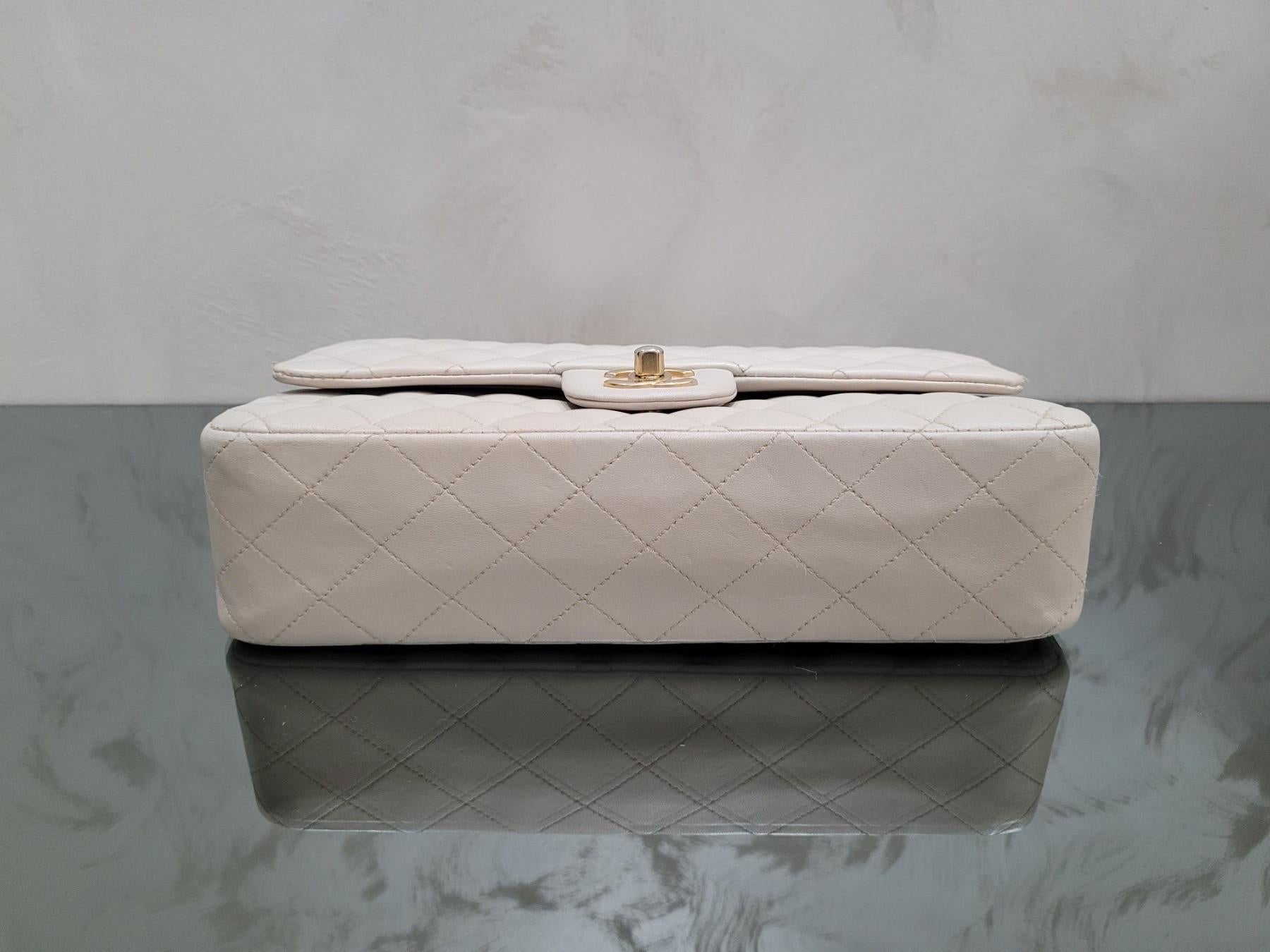Diese elfenbeinfarbene Chanel Medium Double Flap Bag ist ein zeitloses Stück, das jedes Outfit aufwerten wird! 

Die aus luxuriösem beigem Lammleder gefertigte Tasche mit atemberaubenden Goldbeschlägen wurde professionell restauriert und ist in sehr