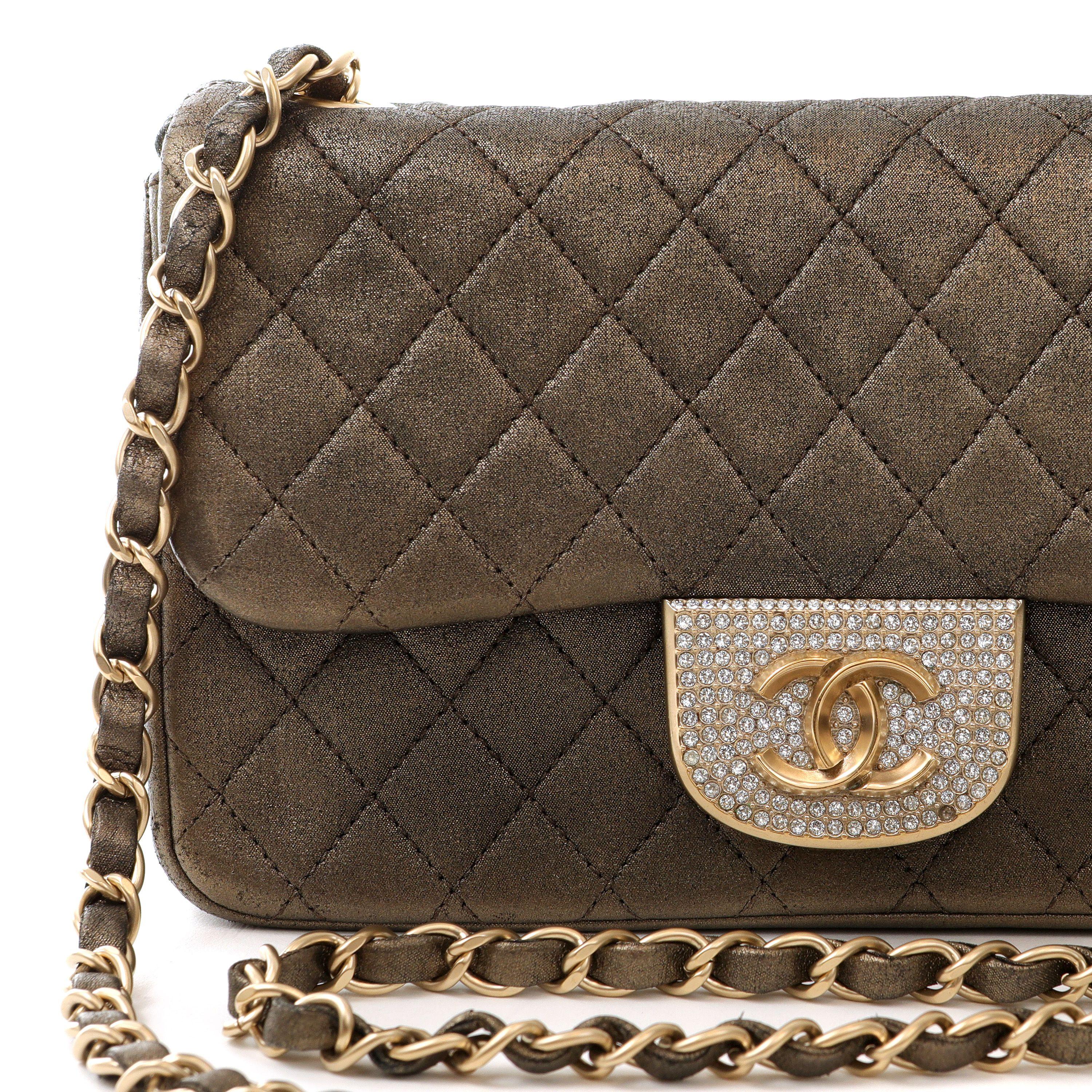 This authentic Chanel Metallic Black and Gold Crystal Flap bag is an exquisite piece in pristine condition.  Subtly metallic black fabric flap bag is quilted in signature Chanel diamond pattern.  Crystal adorned magnetic closure with matte gold