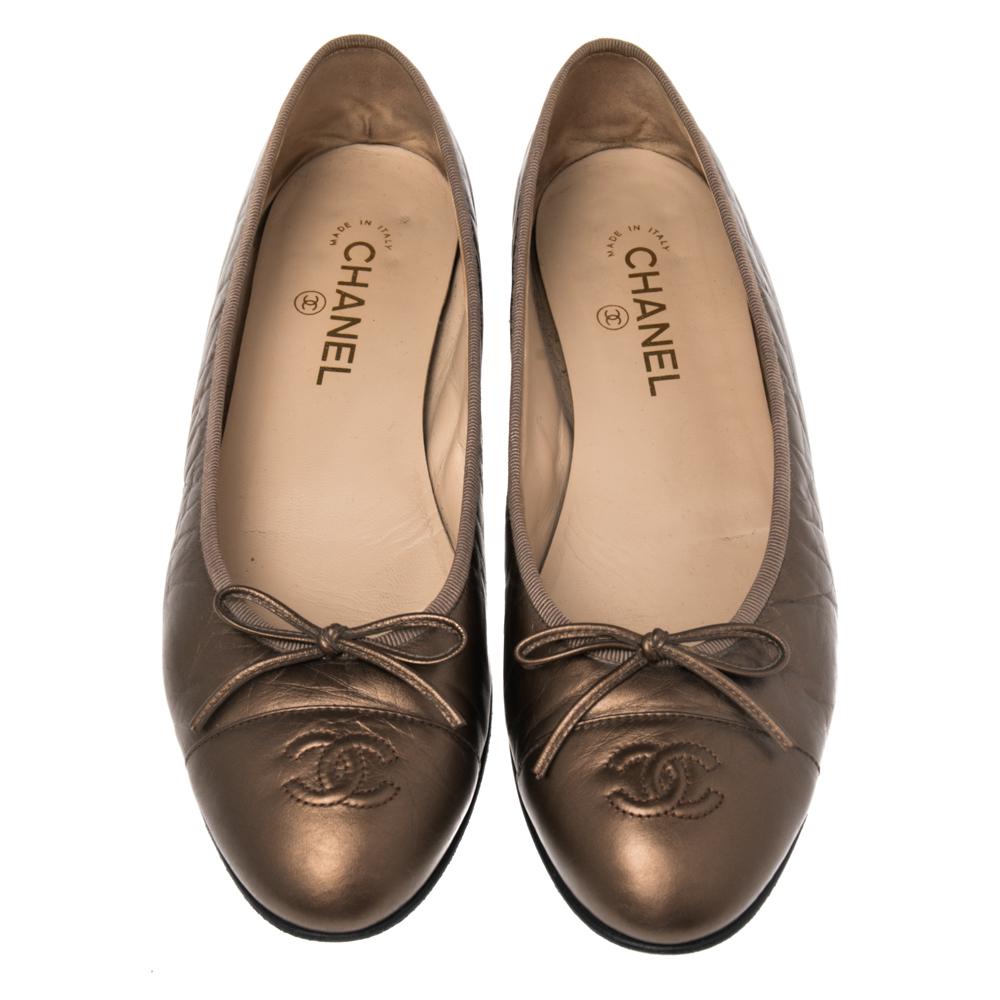 Grant your feet with style and trend like never before as you wear these CC flats from Chanel. Created with metallic bronze leather on the upper and flaunting a bow motif and an embossed logo detail on the front, these flats dutifully provide your