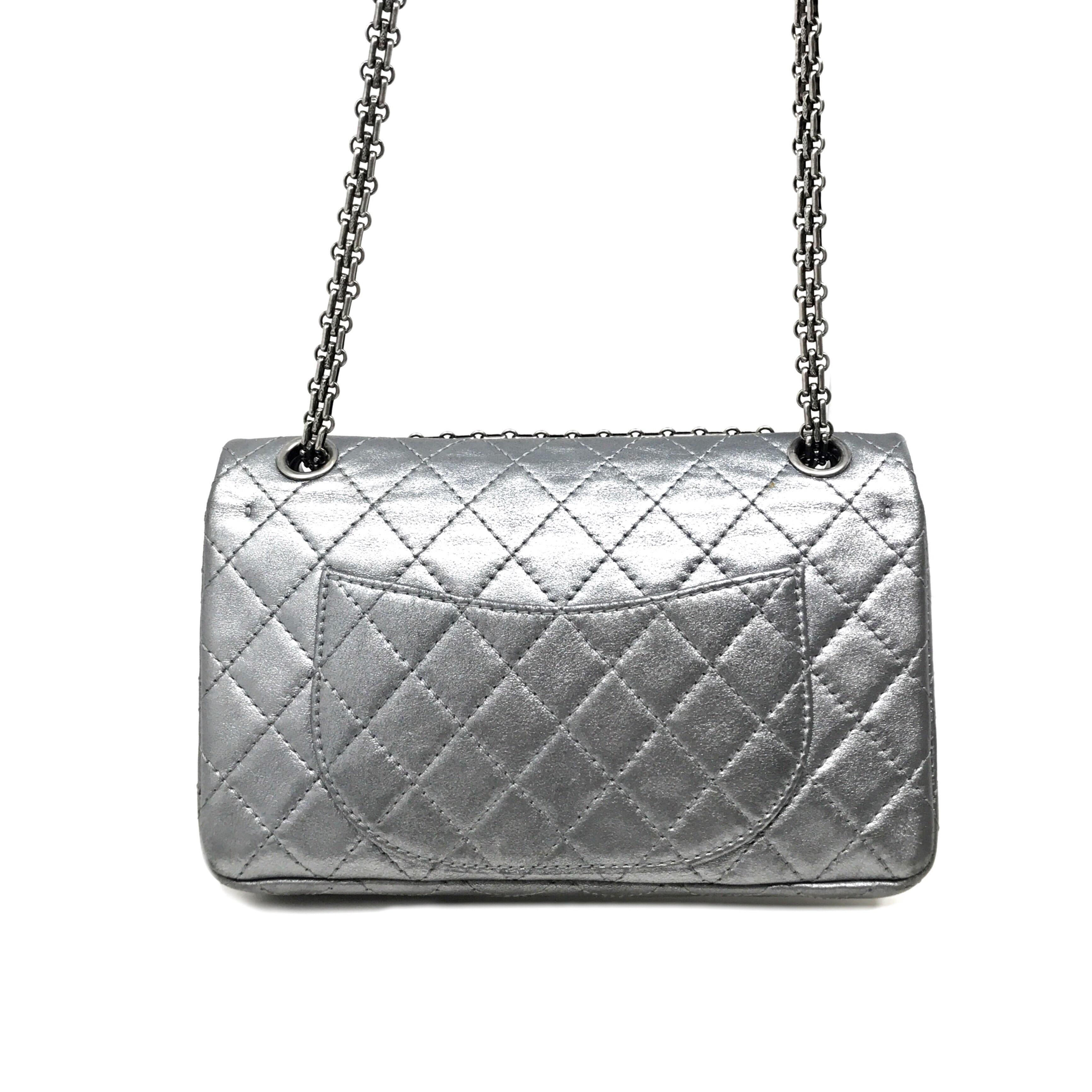 We guarantee this is an authentic CHANEL Metallic Calfskin Quilted Lucky Charms 2.55 Reissue 225 Flap Dark Silver or 100% of your money back. This stylish classic flap shoulder bag is finely crafted of metallic silver diamond quilted calfskin