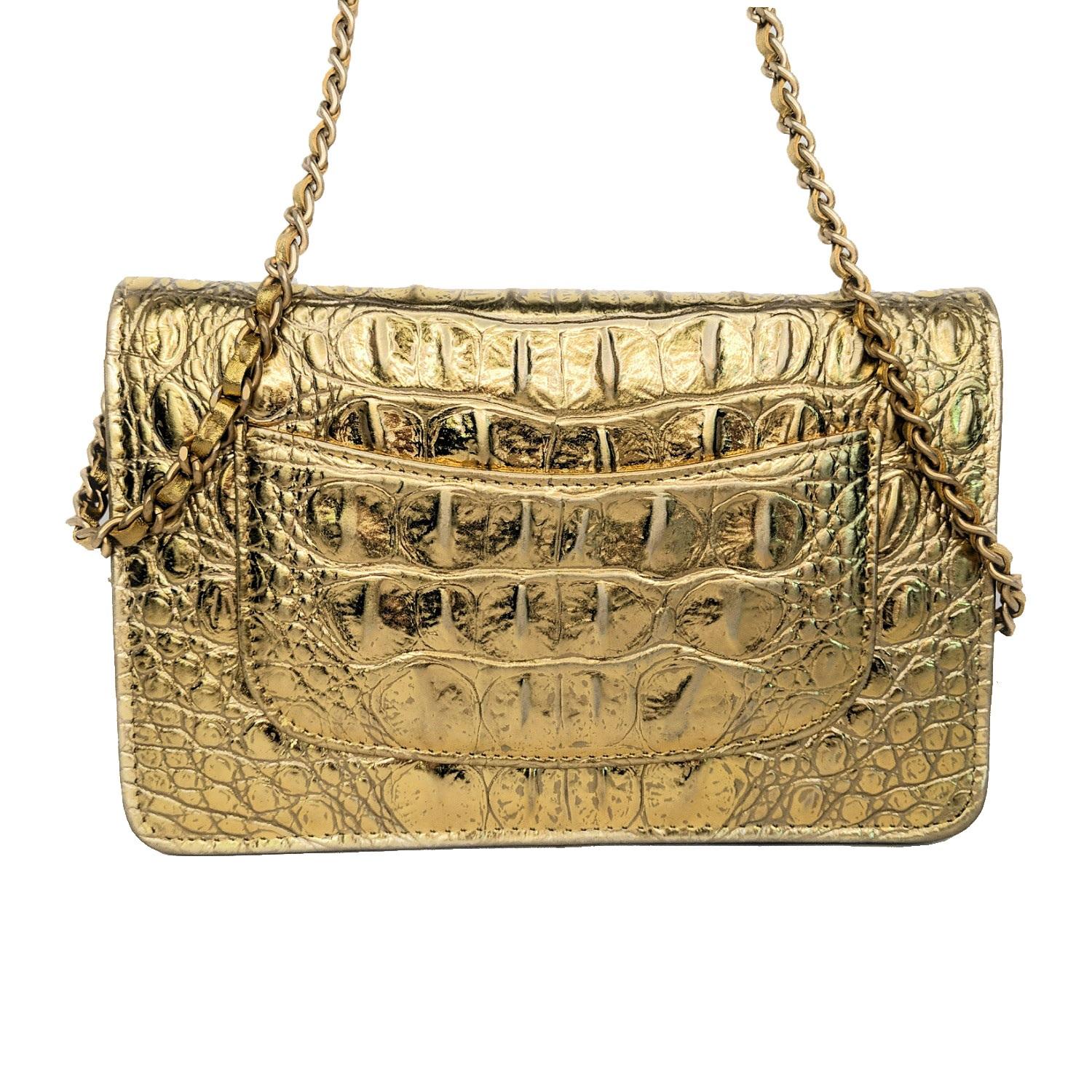 This stylish wallet on a chain is crafted of luxurious metallic embossed calfskin leather in gold. This shoulder bag features an extra long aged gold chain link leather threaded shoulder strap and a front faux aged gold Chanel CC. This unsnaps to a