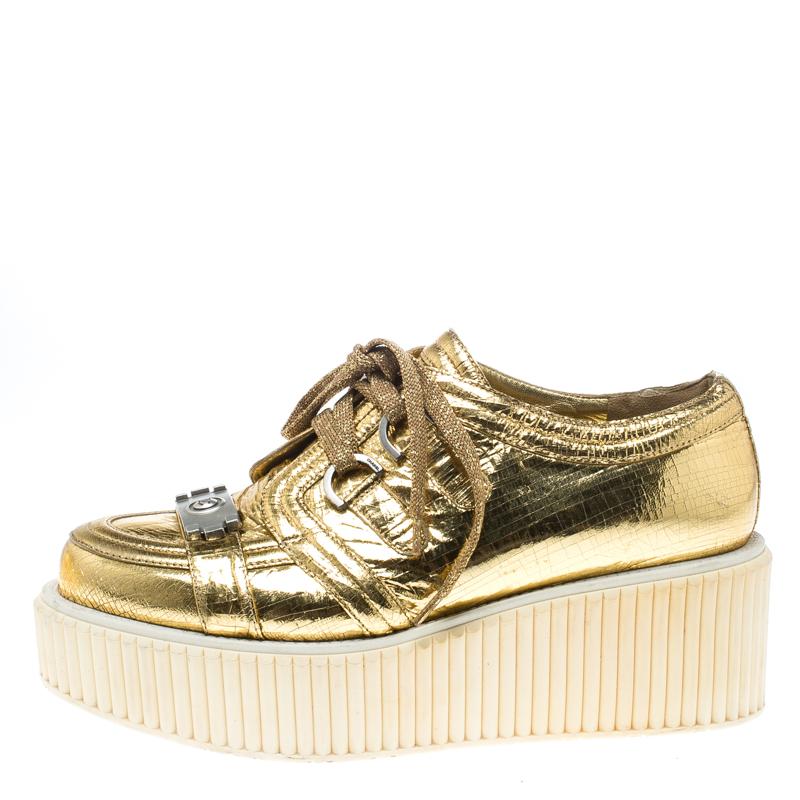 Anything Chanel and we are all doe-eyed! Today, it's this pair of sneakers which are a perfect blend of glamour and style. They are crafted from distressed foil leather carrying a metallic gold hue and are elevated on chunky textured platforms.