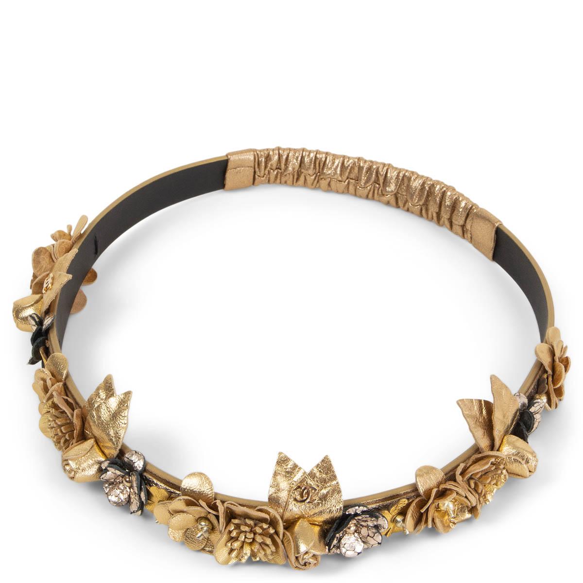 100% authentic Chanel flower embellished calfskin headband in metallic gold-tone. Has various sized camilla flowers in different shades of gold, with a mini Chanel CC logo, and a elastic band on the back. Has been worn and is in excellent condition.
