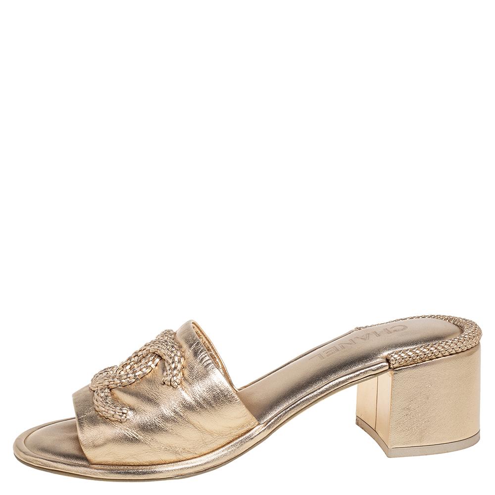 Pretty and easy to flaunt, this pair of sandals by Chanel is a stunner. They've been crafted from metallic gold leather and styled with a woven CC logo on the uppers. Open toes, short heels, and sturdy leather soles complete the pair.

Includes: