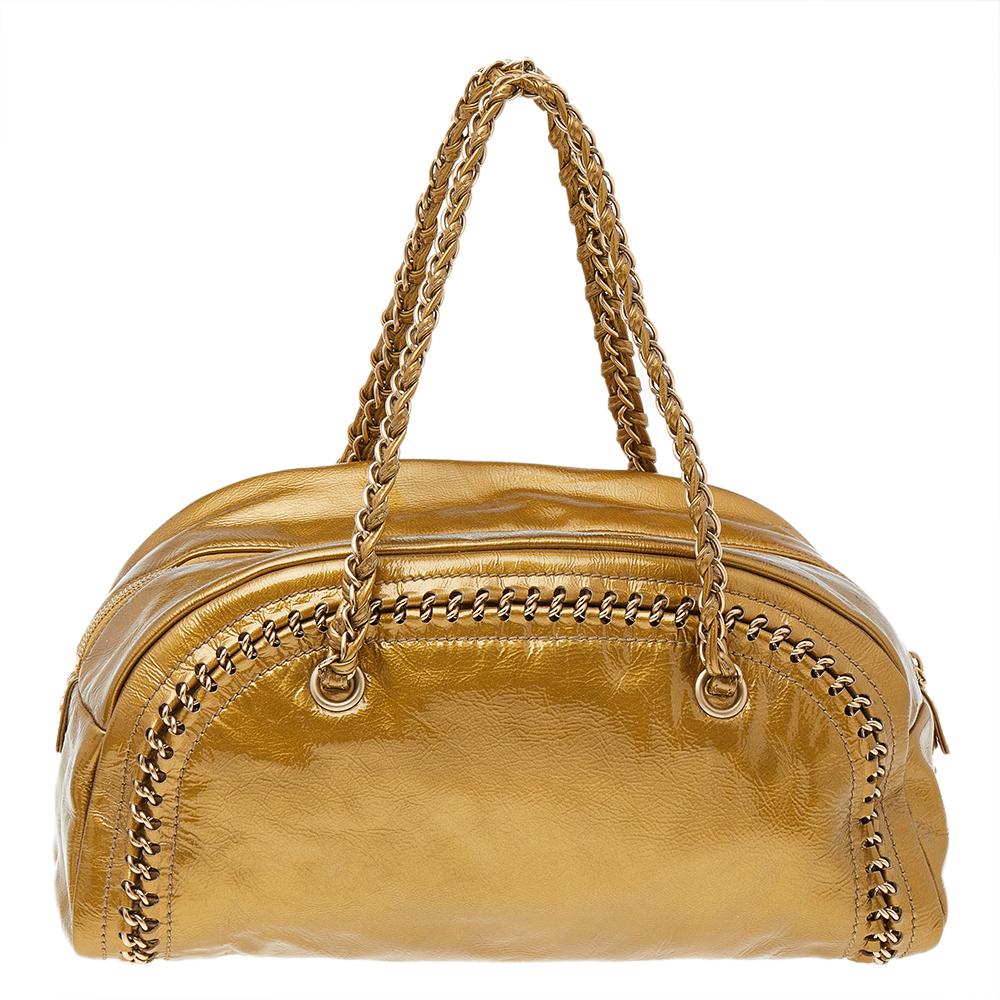 This Luxe Ligne Bowler bag is a classy creation by Chanel. It features a chain-detailed leather exterior in metallic gold with the CC logo on the front and two chain handles on top. The zip opens up to a lined interior.

Includes: Original Dustbag
