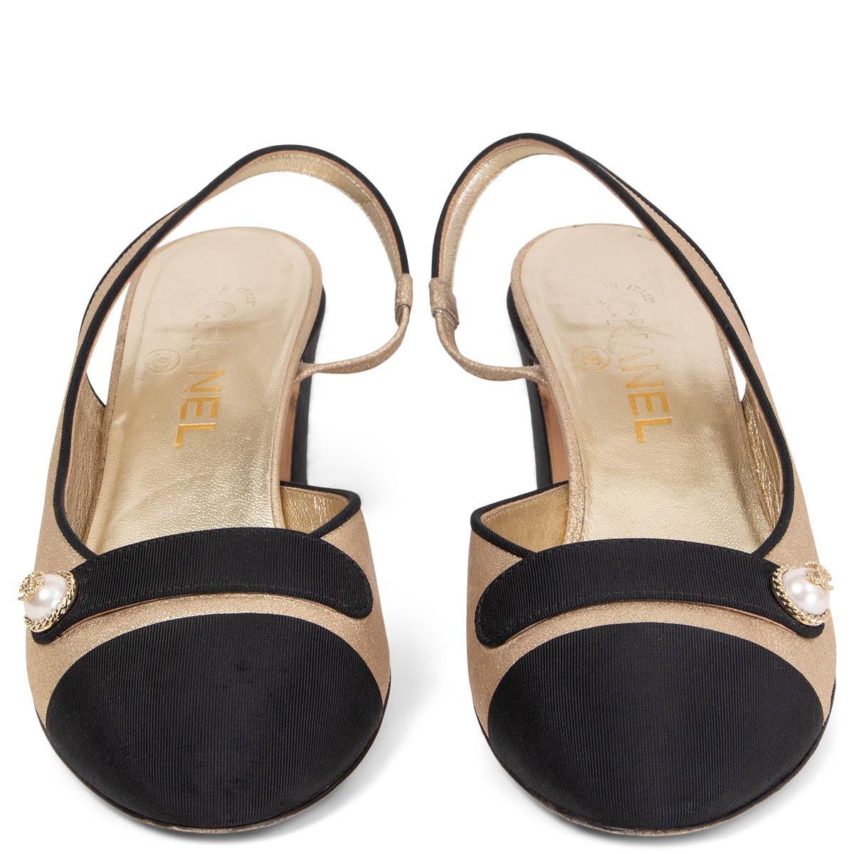 100% authentic Chanel round-tone slingbacks in light gold-tone metallic calfskin featuring classic black grosgrain tip and decorative band with pearls and CC logo embellishment. Have been worn and show very faint wear to the grosgrain tip on the