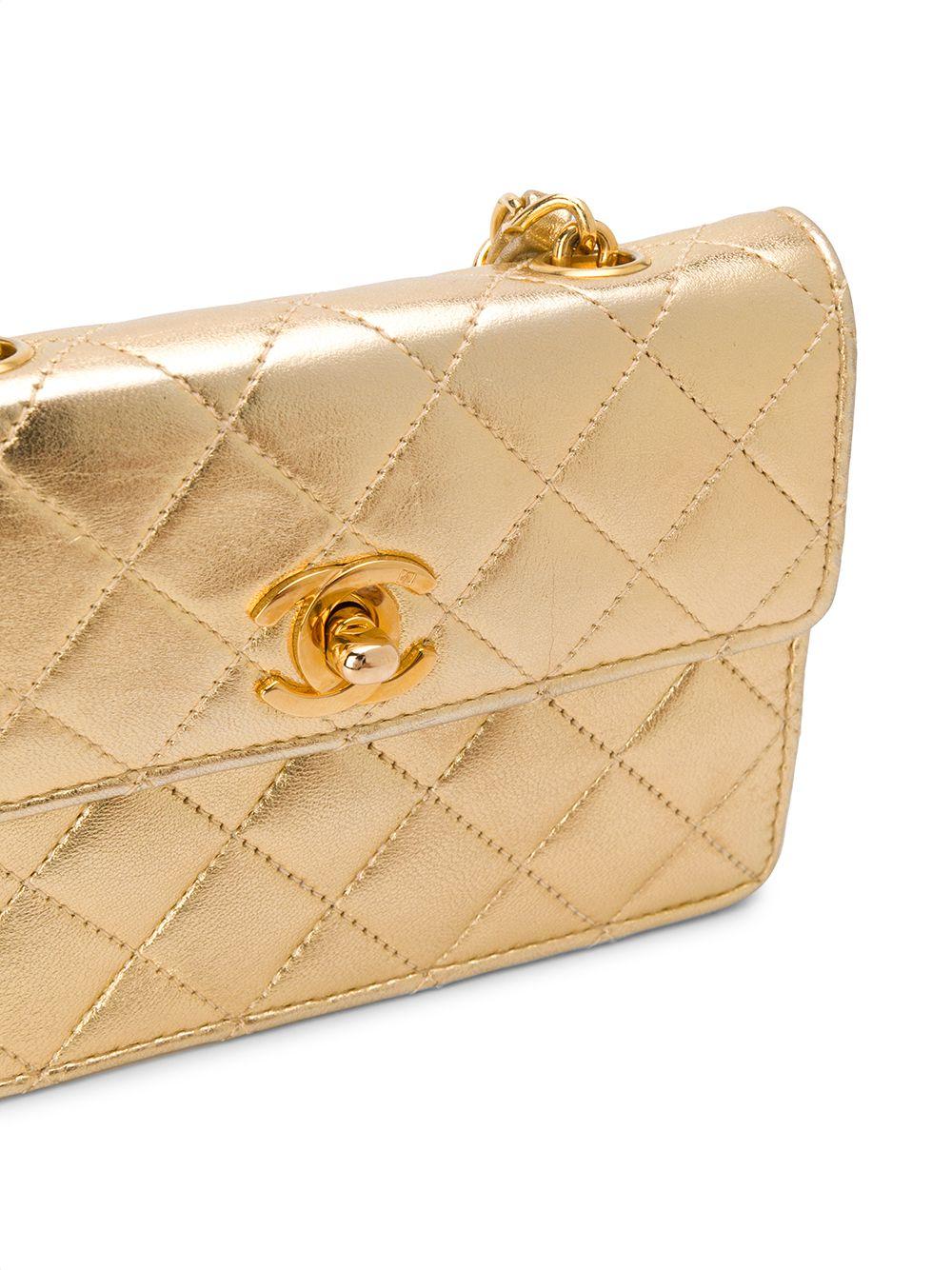 Crafted in France from an intricately luxurious combination of gold calfskin leather and yellow-gold tone metal, this timeless pre-loved Chanel crossbody bag features a diamond quilted finish, an opulent metallic sheen, and a leather laced chain